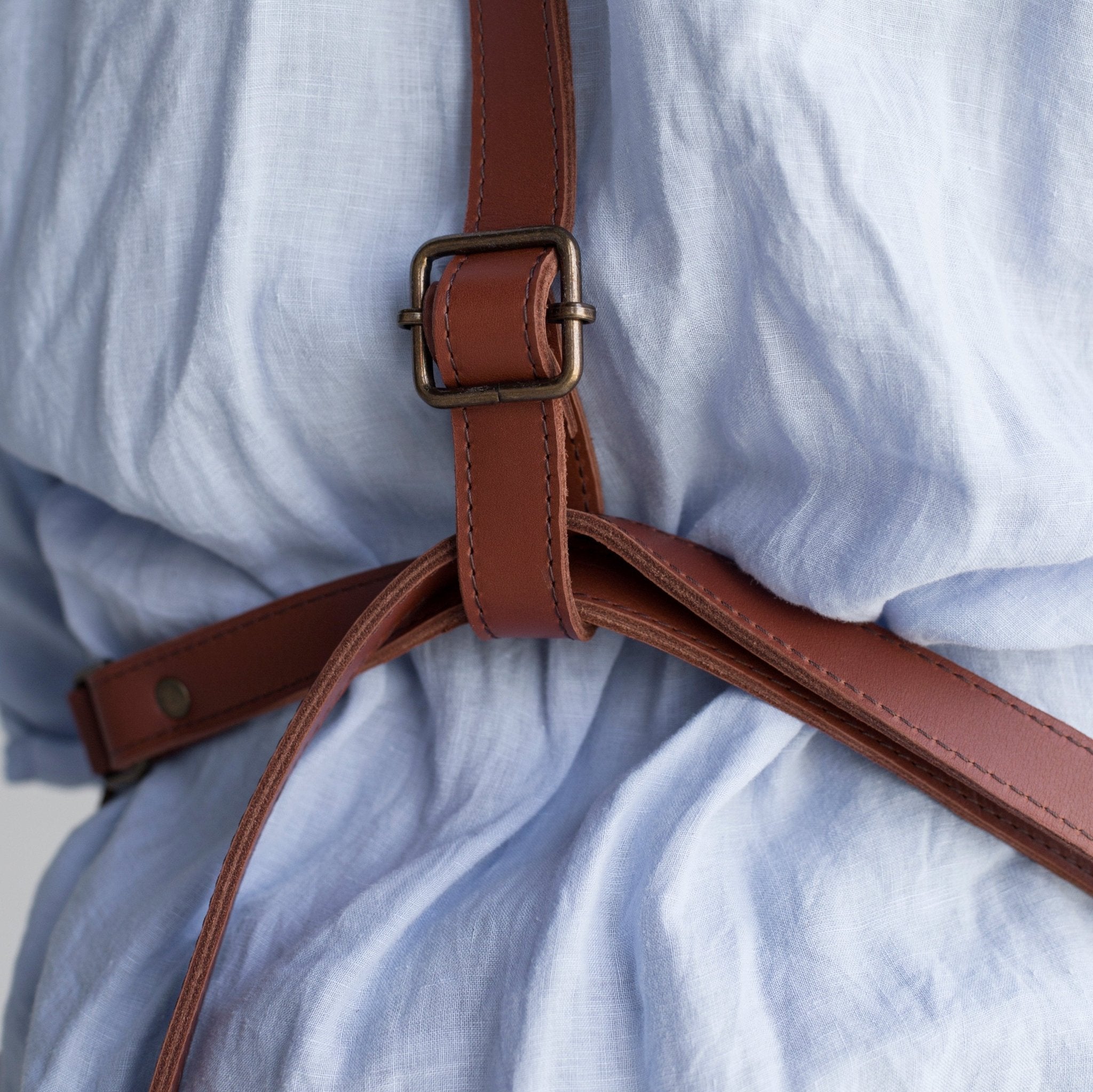 Full leather apron, adjustable straps, front chest pocket, tool loops, and rich texture, ideal for grilling, crafts, shop use