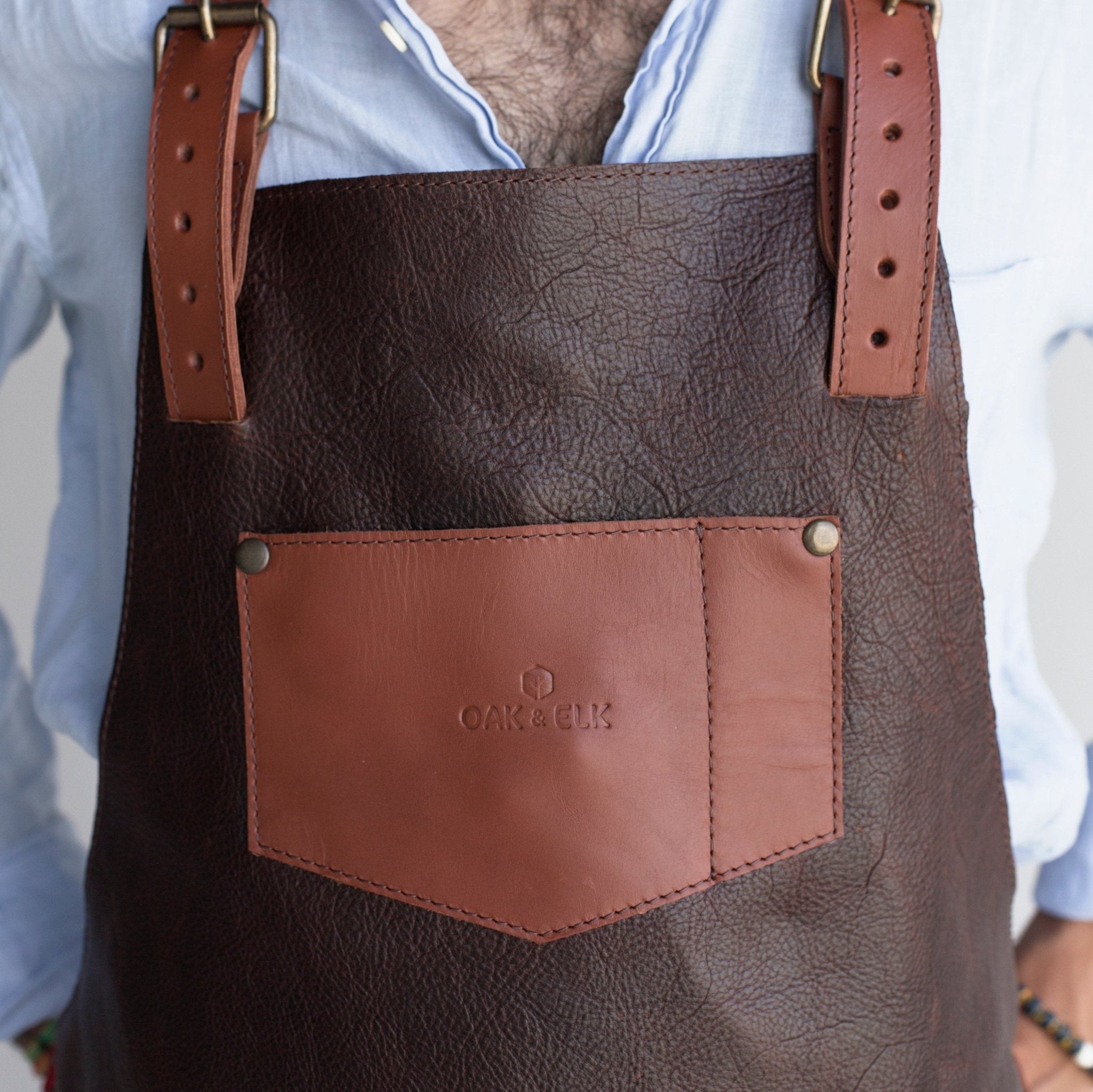 Full leather apron, adjustable straps, front chest pocket, tool loops, and rich texture, ideal for grilling, crafts, shop use