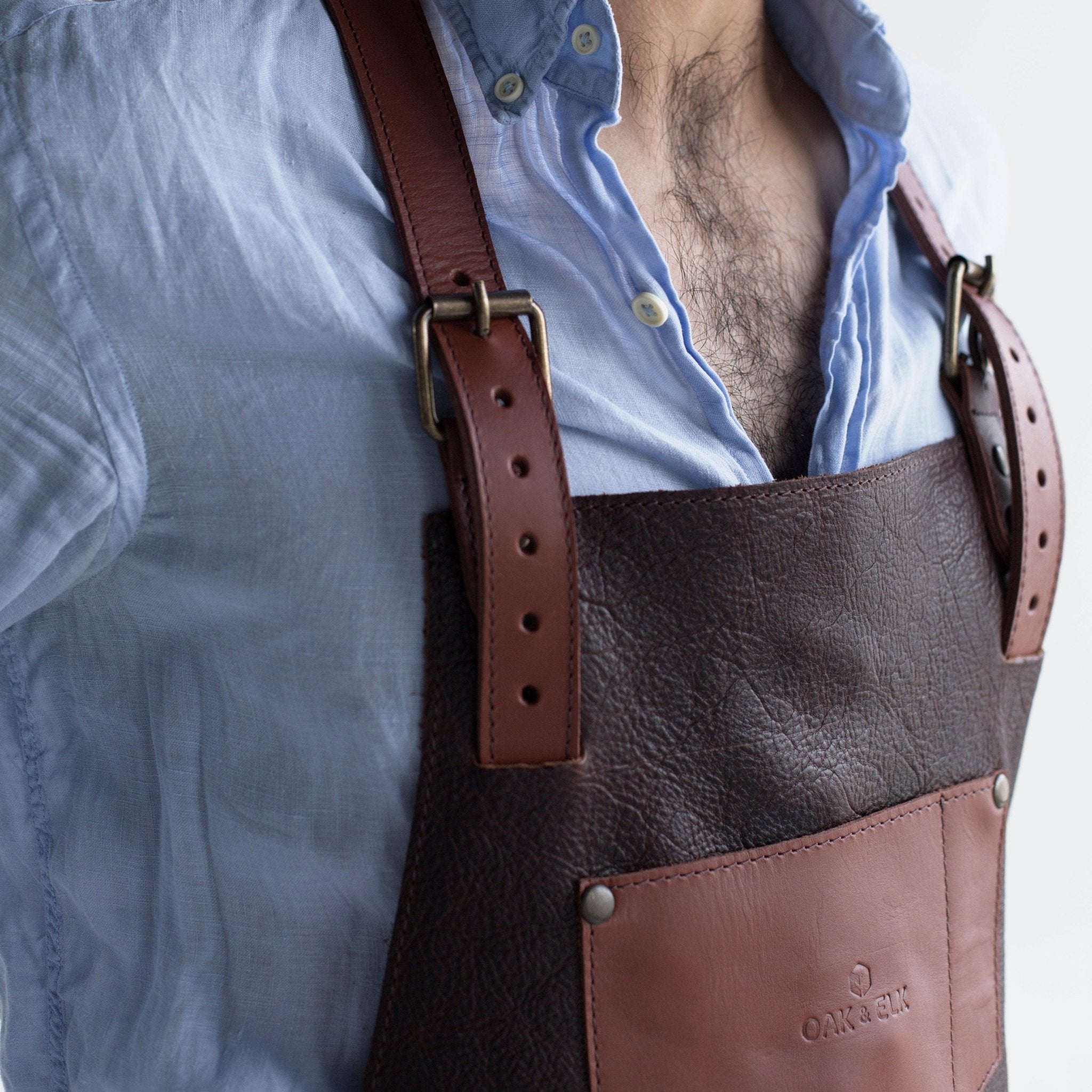 Full leather apron, adjustable straps, front chest pocket, tool loops, and rich texture, ideal for grilling, crafts, shop use