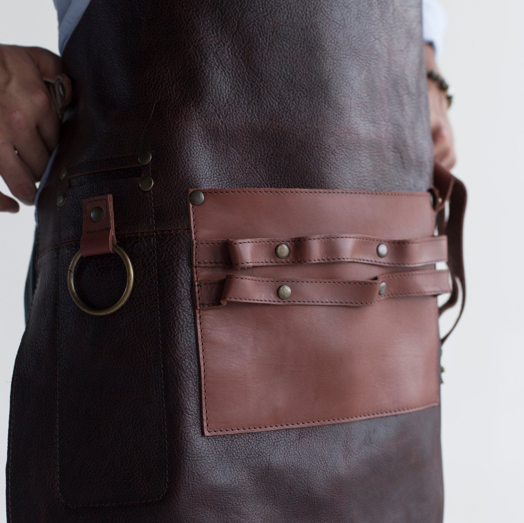 Full leather apron, adjustable straps, front chest pocket, tool loops, and rich texture, ideal for grilling, crafts, shop use