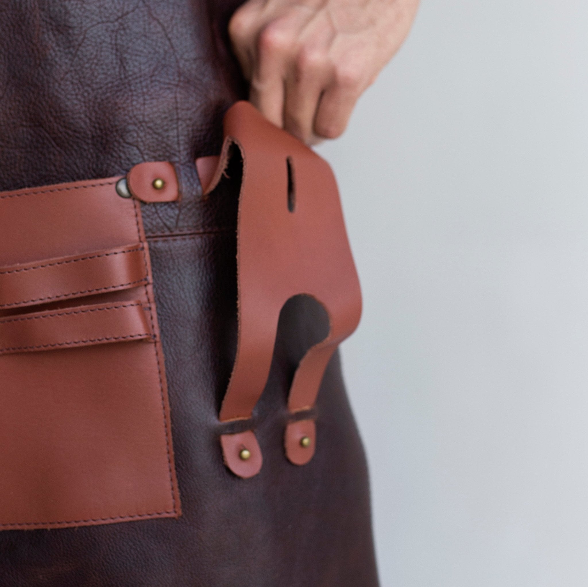 Full leather apron, adjustable straps, front chest pocket, tool loops, and rich texture, ideal for grilling, crafts, shop use