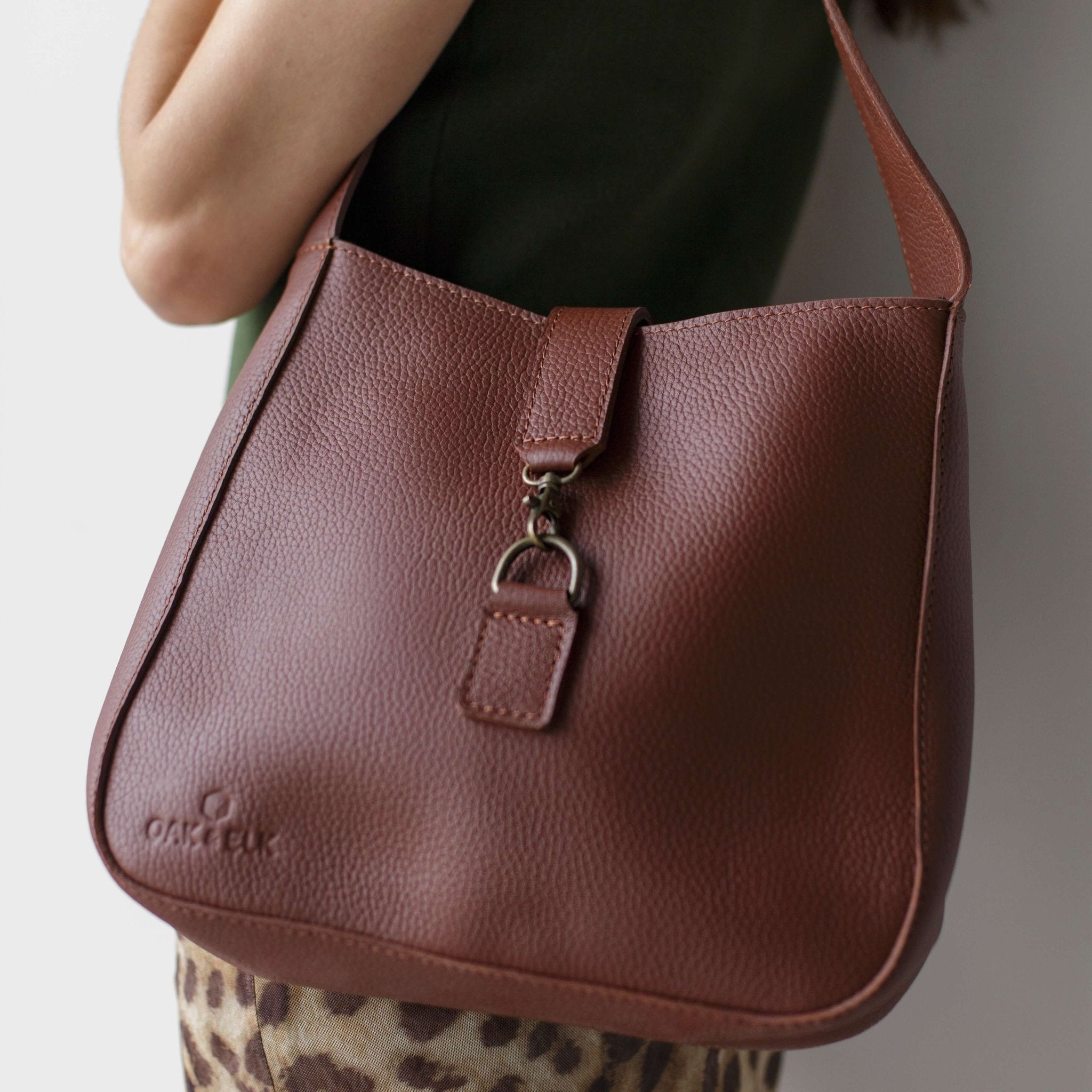 Full-grain leather shoulder bag with minimalist design, adjustable strap, interior pocket, soft structure, everyday essential