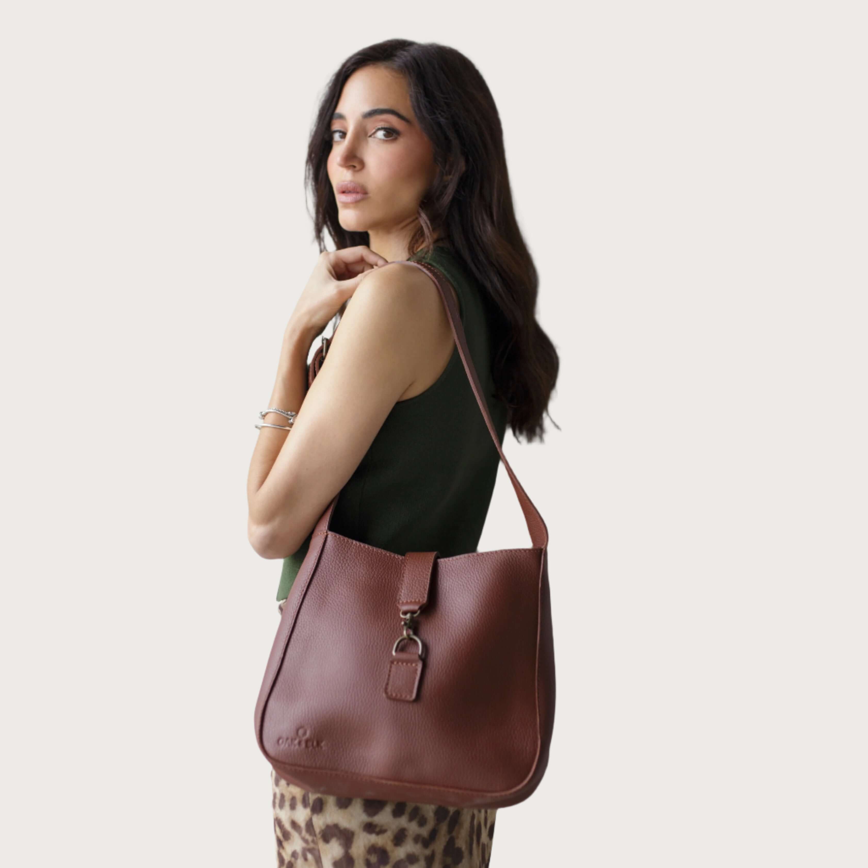 Full-grain leather shoulder bag with minimalist design, adjustable strap, interior pocket, soft structure, everyday essential