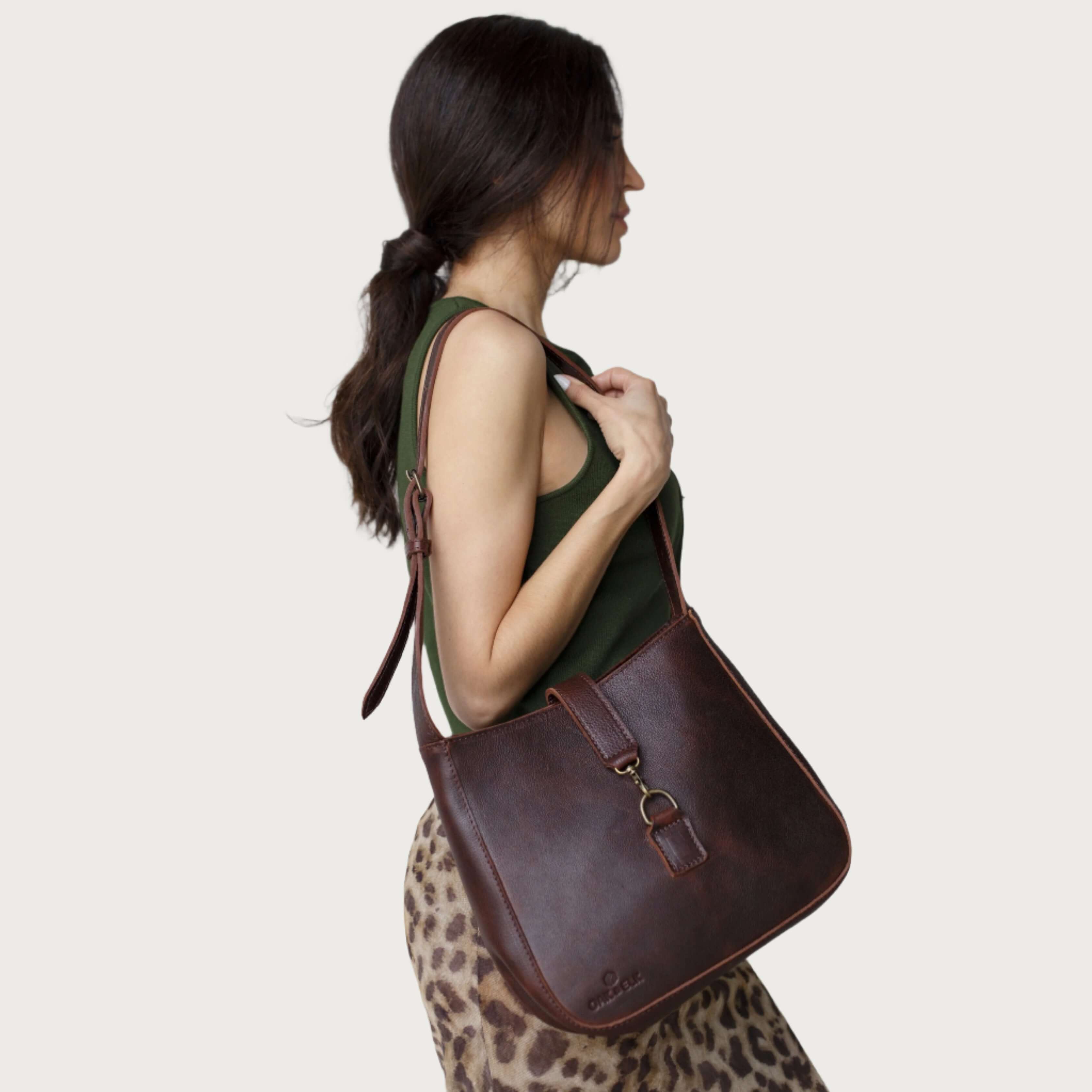 Full-grain leather shoulder bag with minimalist design, adjustable strap, interior pocket, soft structure, everyday essential