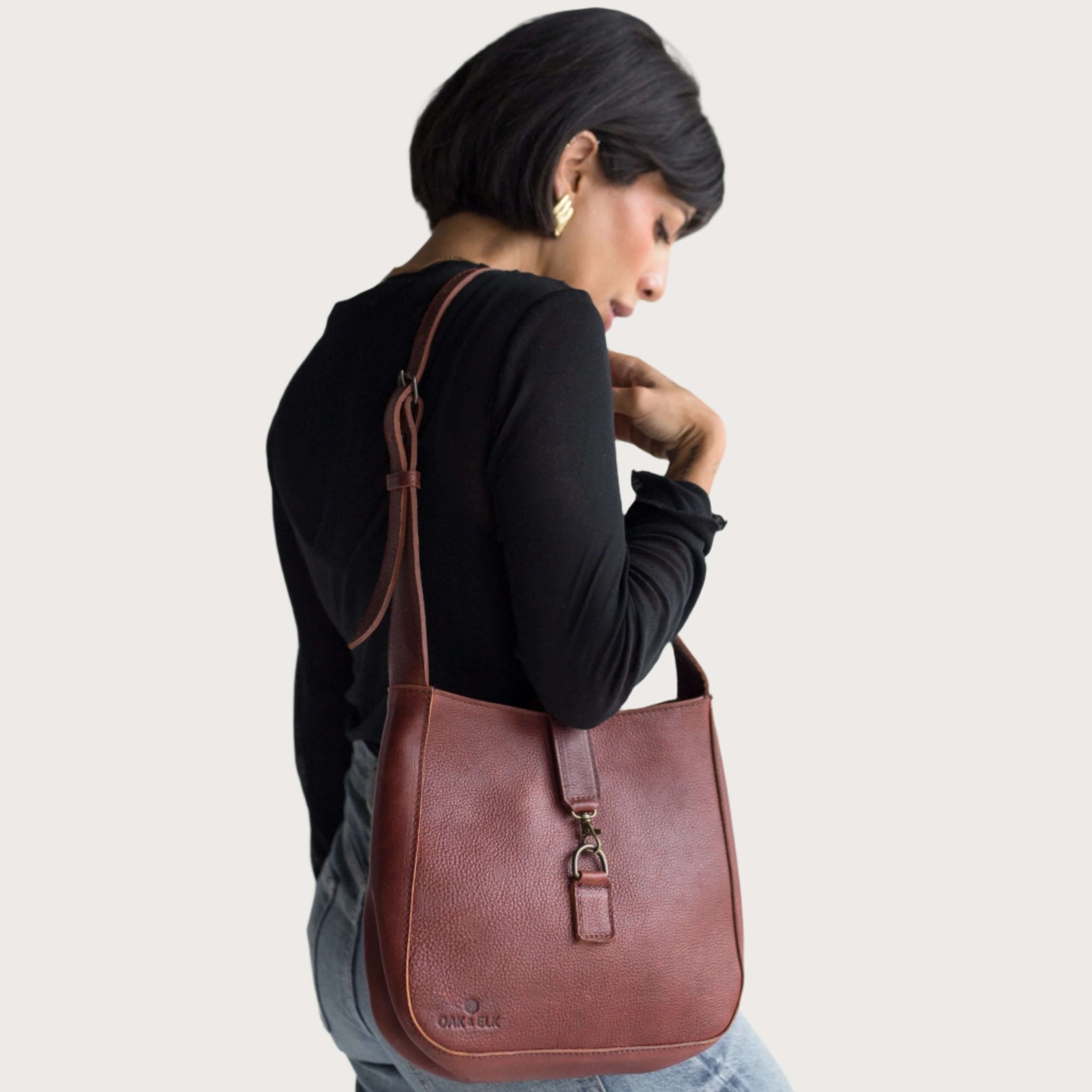 Full-grain leather shoulder bag with minimalist design, adjustable strap, interior pocket, soft structure, everyday essential