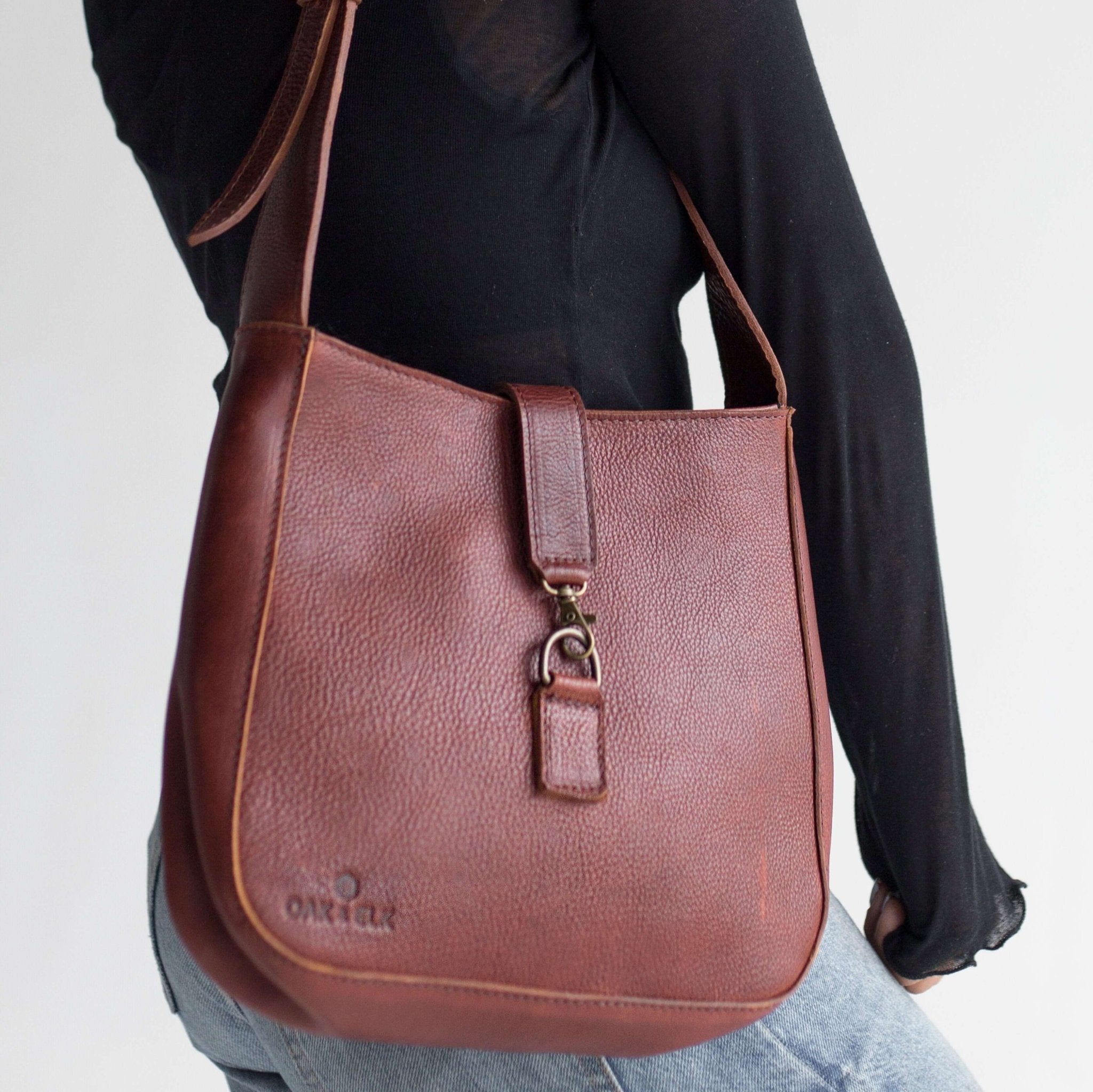 Full-grain leather shoulder bag with minimalist design, adjustable strap, interior pocket, soft structure, everyday essential