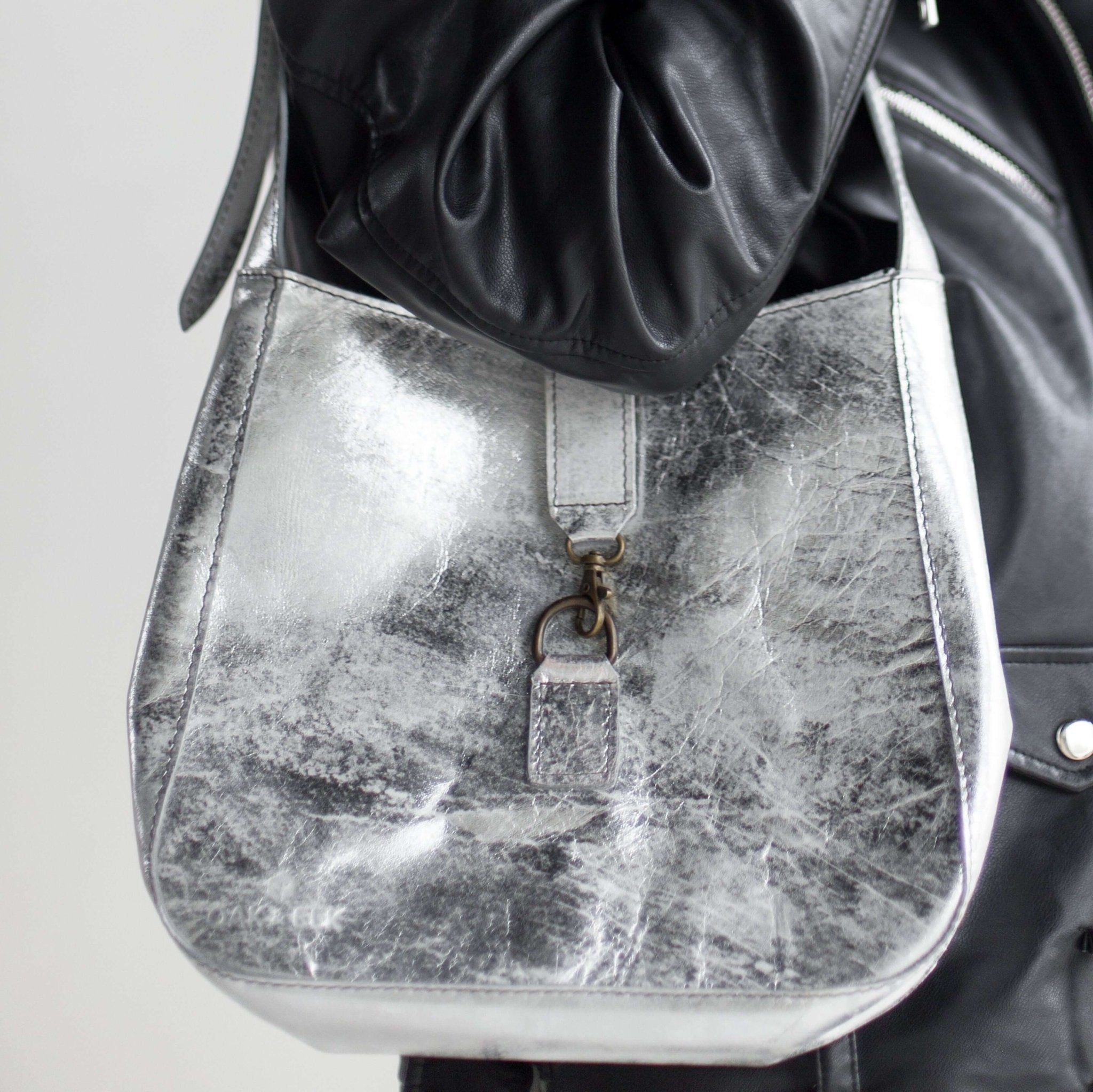 Full-grain leather shoulder bag with minimalist design, adjustable strap, interior pocket, soft structure, everyday essential