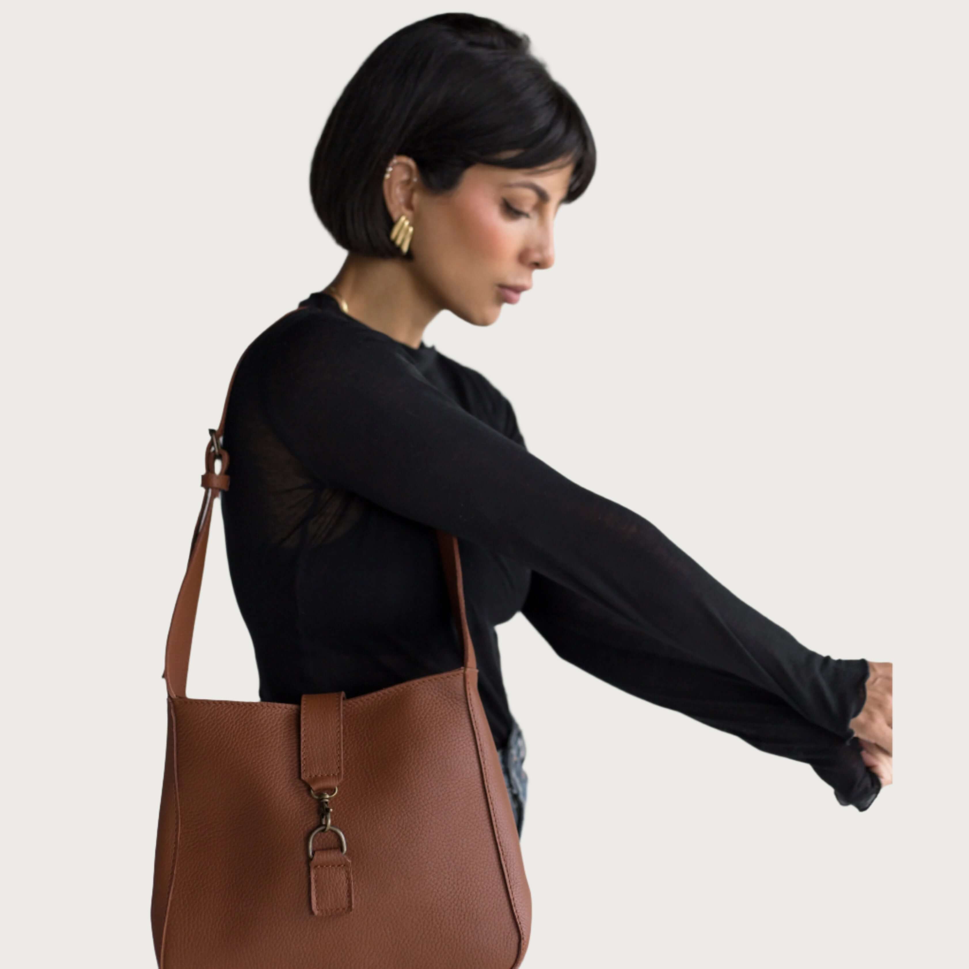 Full-grain leather shoulder bag with minimalist design, adjustable strap, interior pocket, soft structure, everyday essential