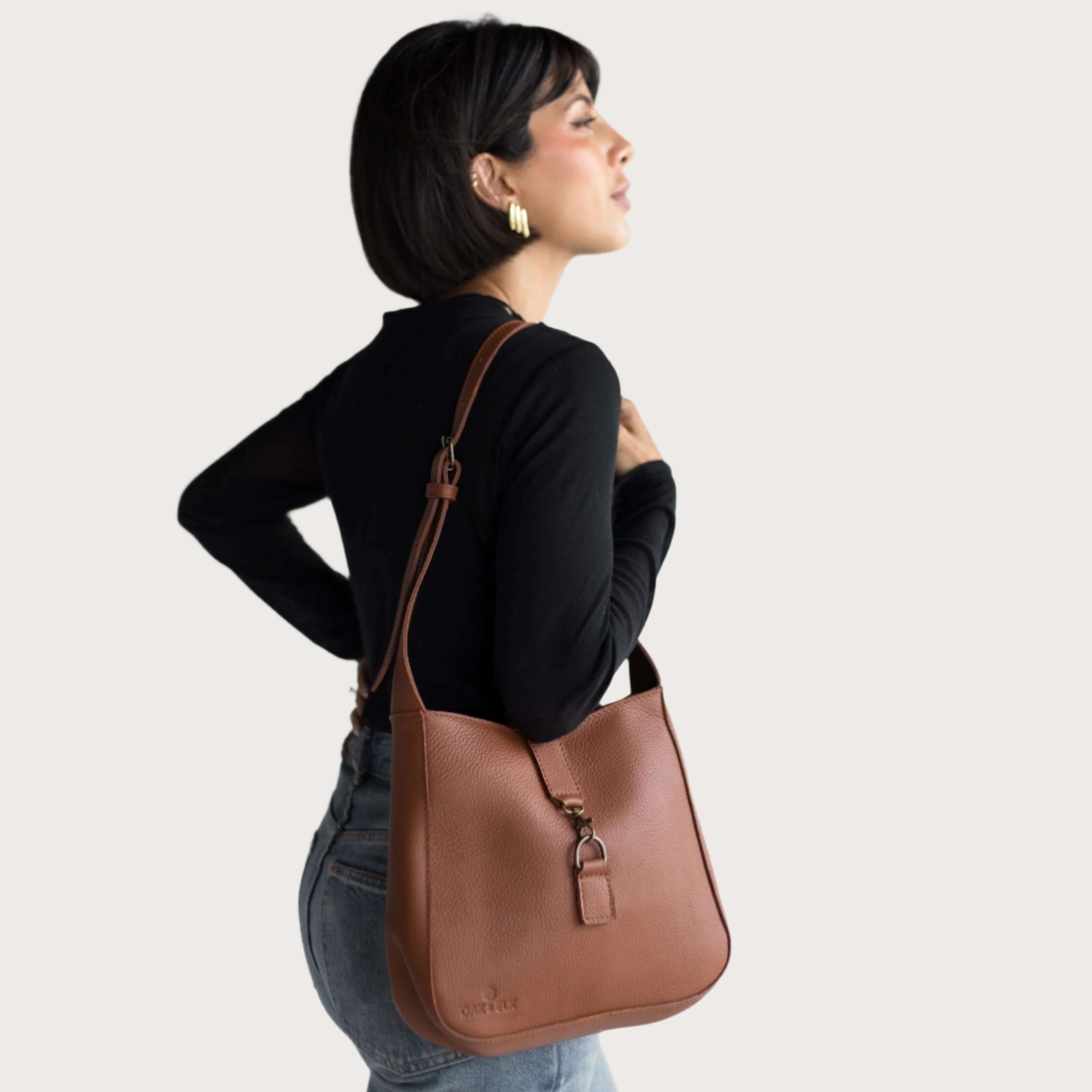 Full-grain leather shoulder bag with minimalist design, adjustable strap, interior pocket, soft structure, everyday essential