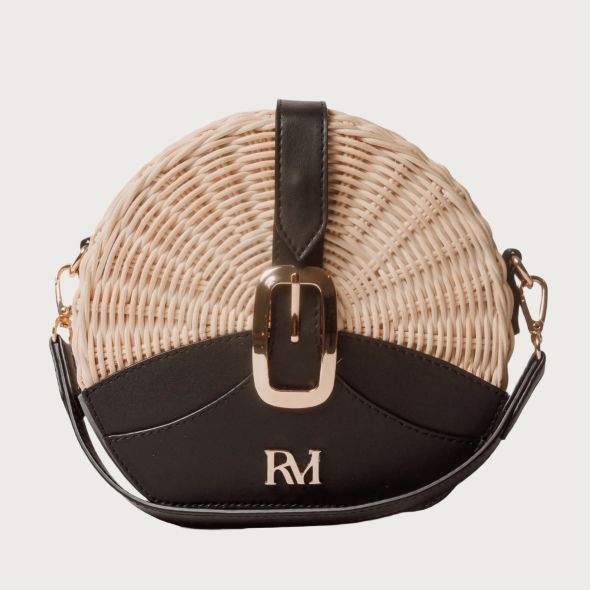 Round wicker and black leather crossbody bag with flap closure, gold chain strap, and structured shape unique eye-catching.