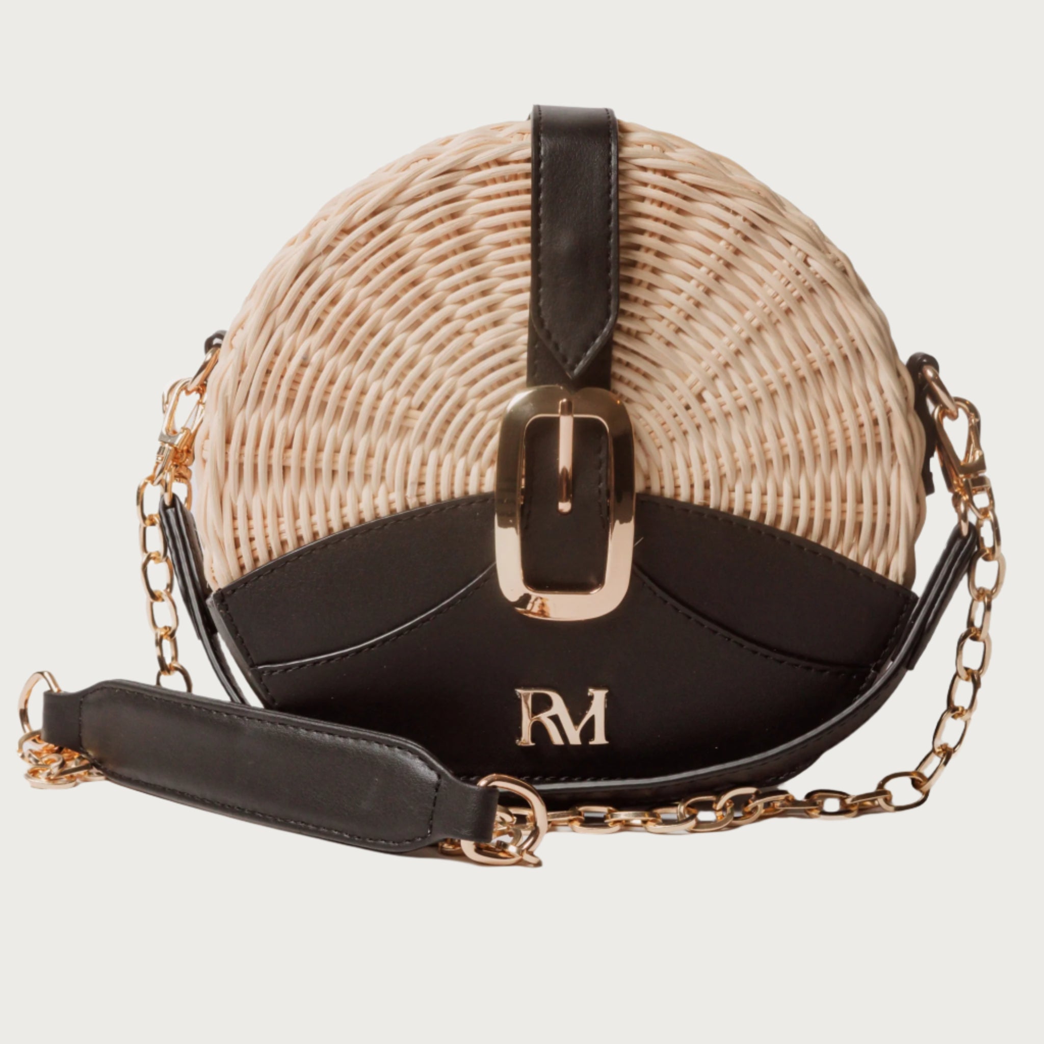 Round wicker and black leather crossbody bag with flap closure, gold chain strap, and structured shape unique eye-catching.