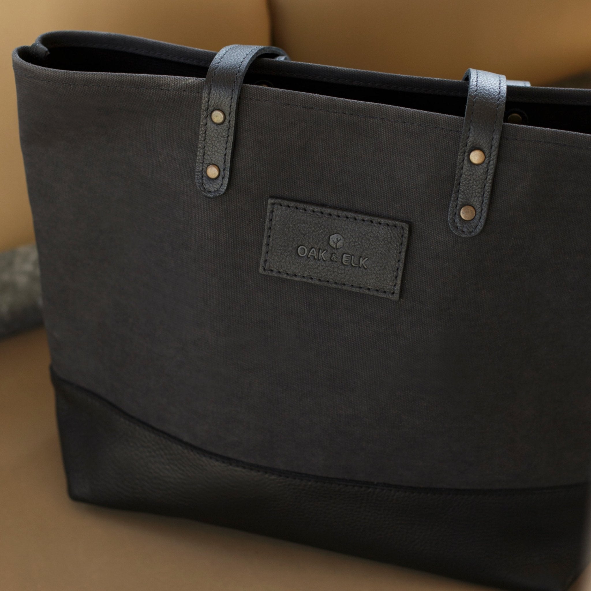 Canvas tote bag with leather trim, double shoulder straps, minimalist design, and roomy interior — ideal for daily use.