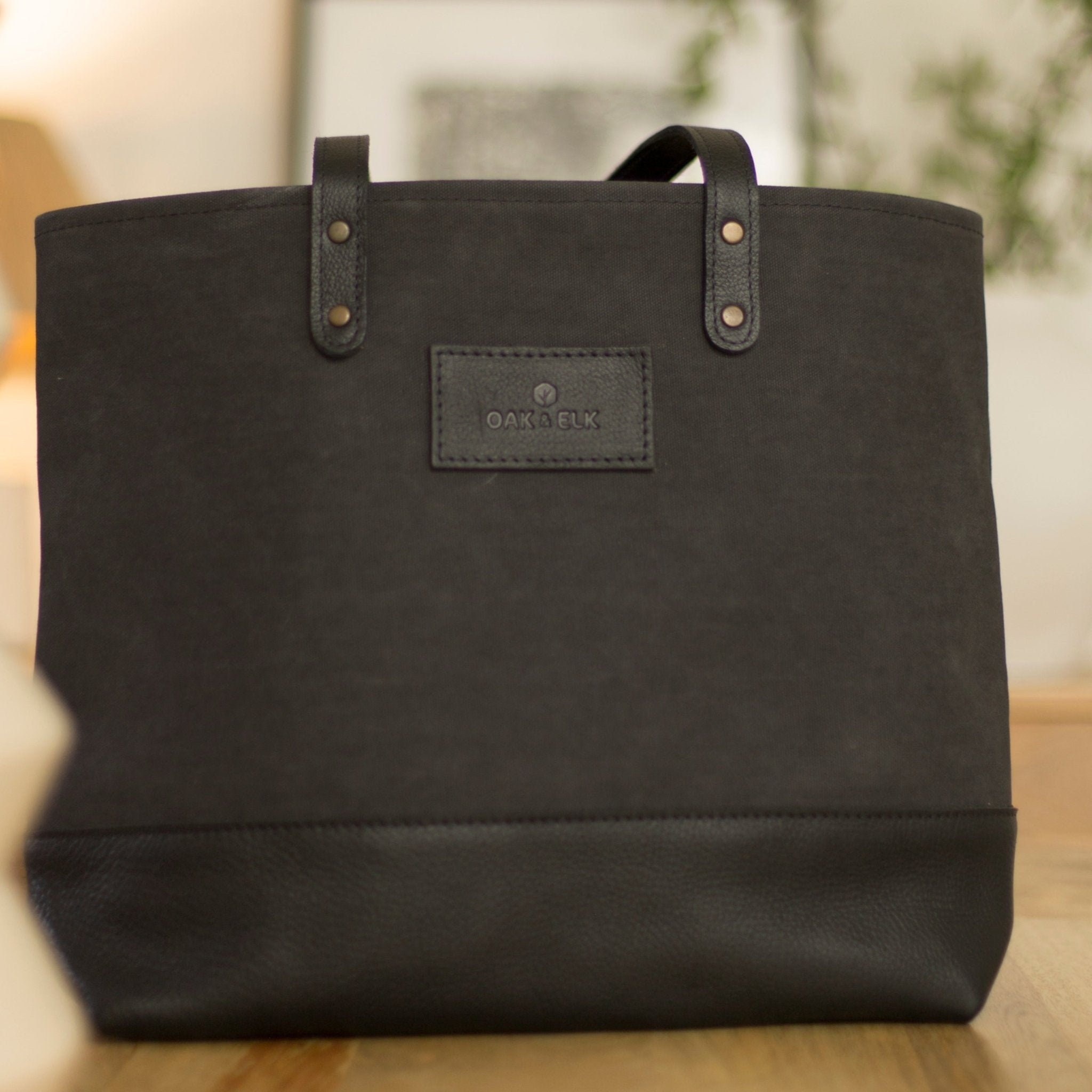 Canvas tote bag with leather trim, double shoulder straps, minimalist design, and roomy interior — ideal for daily use.