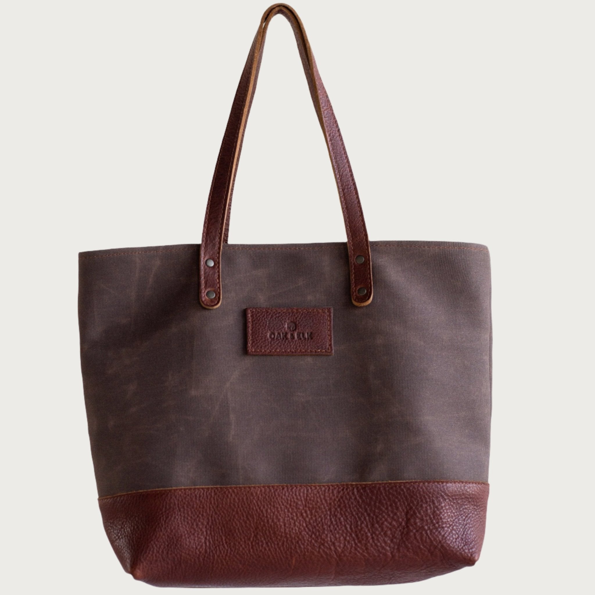 Canvas tote bag with leather trim, double shoulder straps, minimalist design, and roomy interior — ideal for daily use.