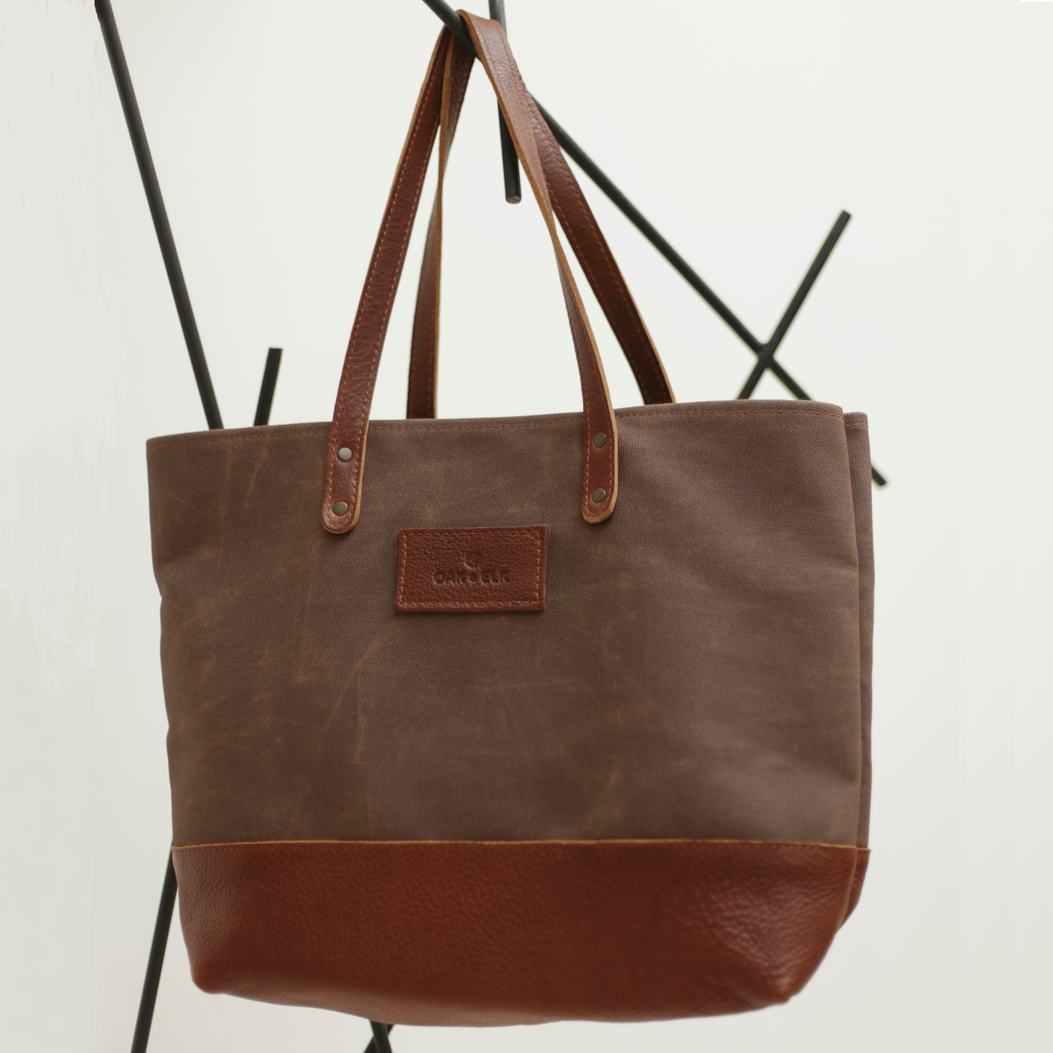 Canvas tote bag with leather trim, double shoulder straps, minimalist design, and roomy interior — ideal for daily use.