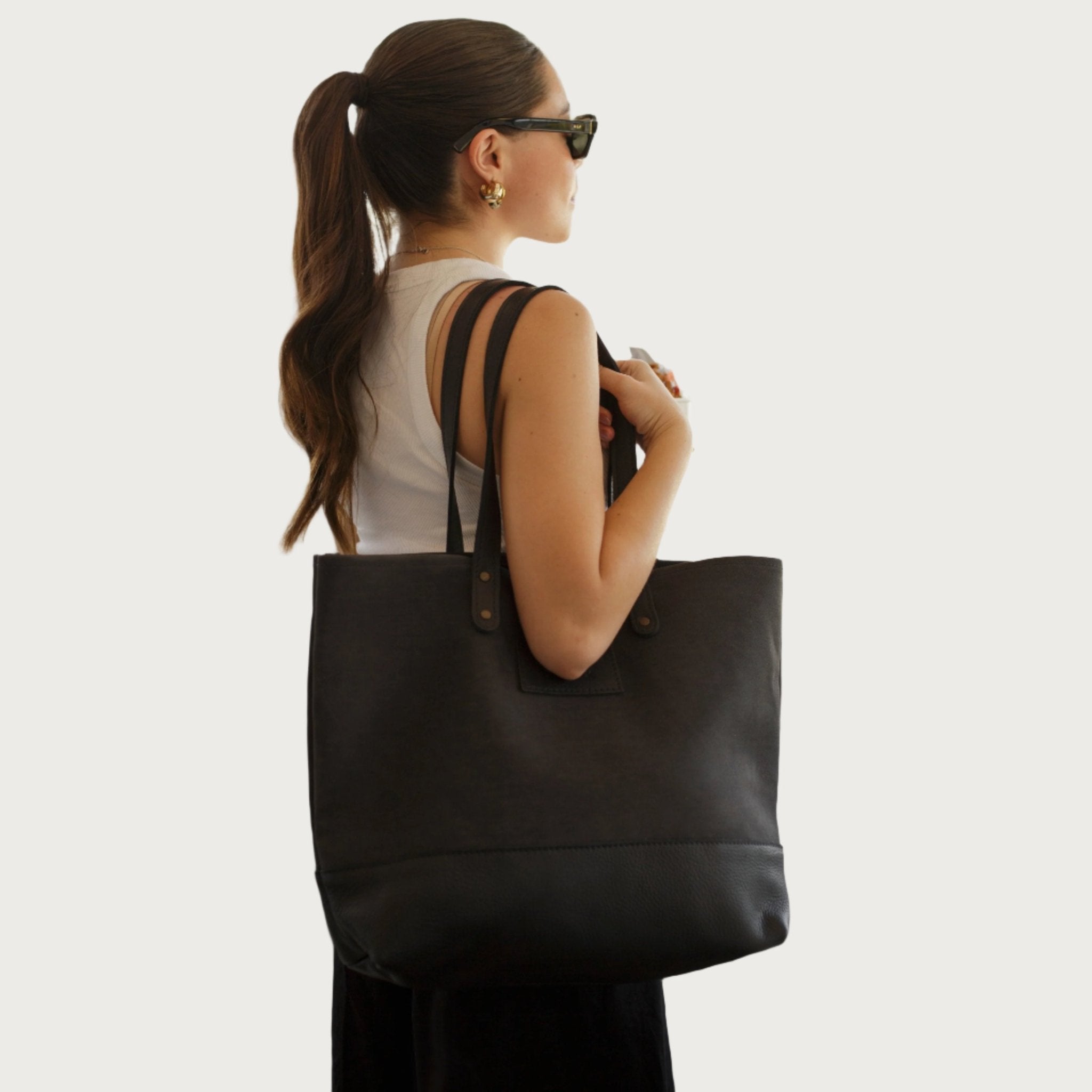 Canvas tote bag with leather trim, double shoulder straps, minimalist design, and roomy interior — ideal for daily use.