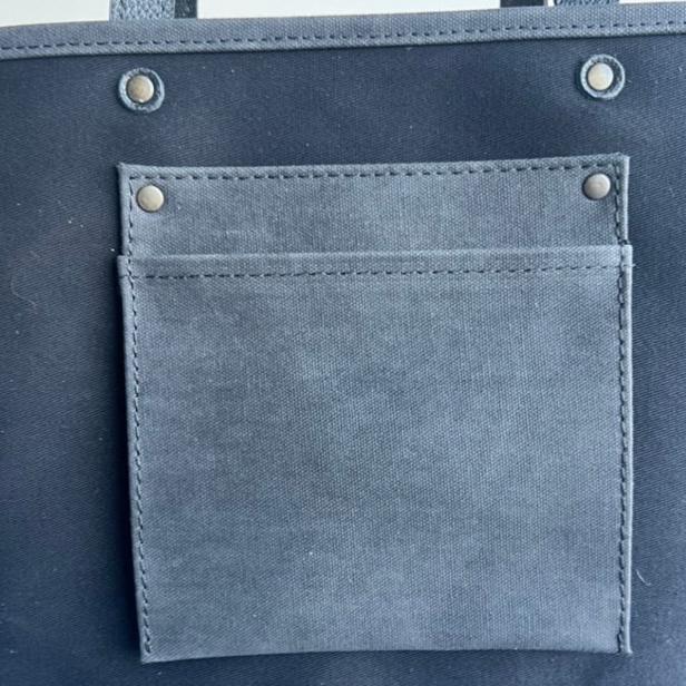 Canvas tote bag with leather trim, double shoulder straps, minimalist design, and roomy interior — ideal for daily use.