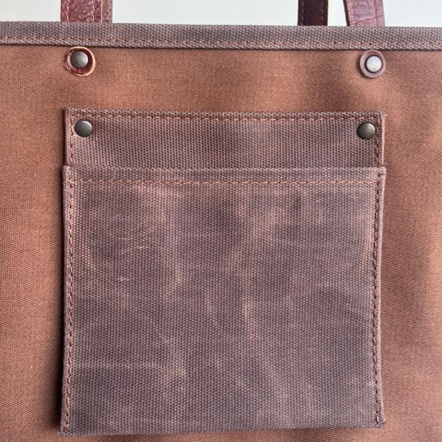 Canvas tote bag with leather trim, double shoulder straps, minimalist design, and roomy interior — ideal for daily use.