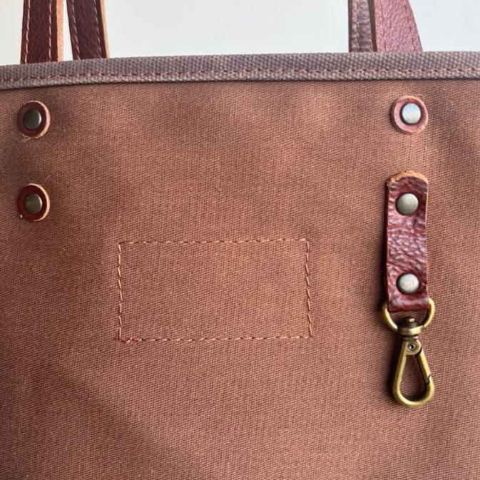 Canvas tote bag with leather trim, double shoulder straps, minimalist design, and roomy interior — ideal for daily use.