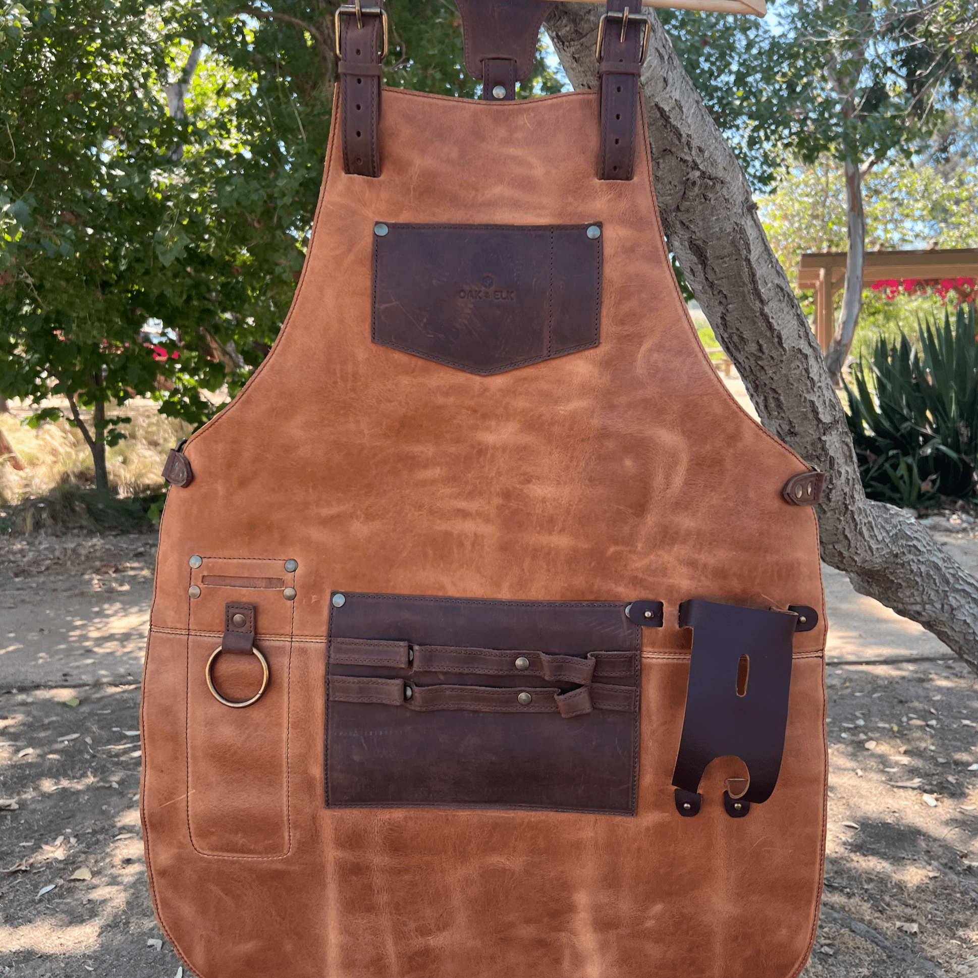 Full leather apron, adjustable straps, front chest pocket, tool loops, and rich texture, ideal for grilling, crafts, shop use