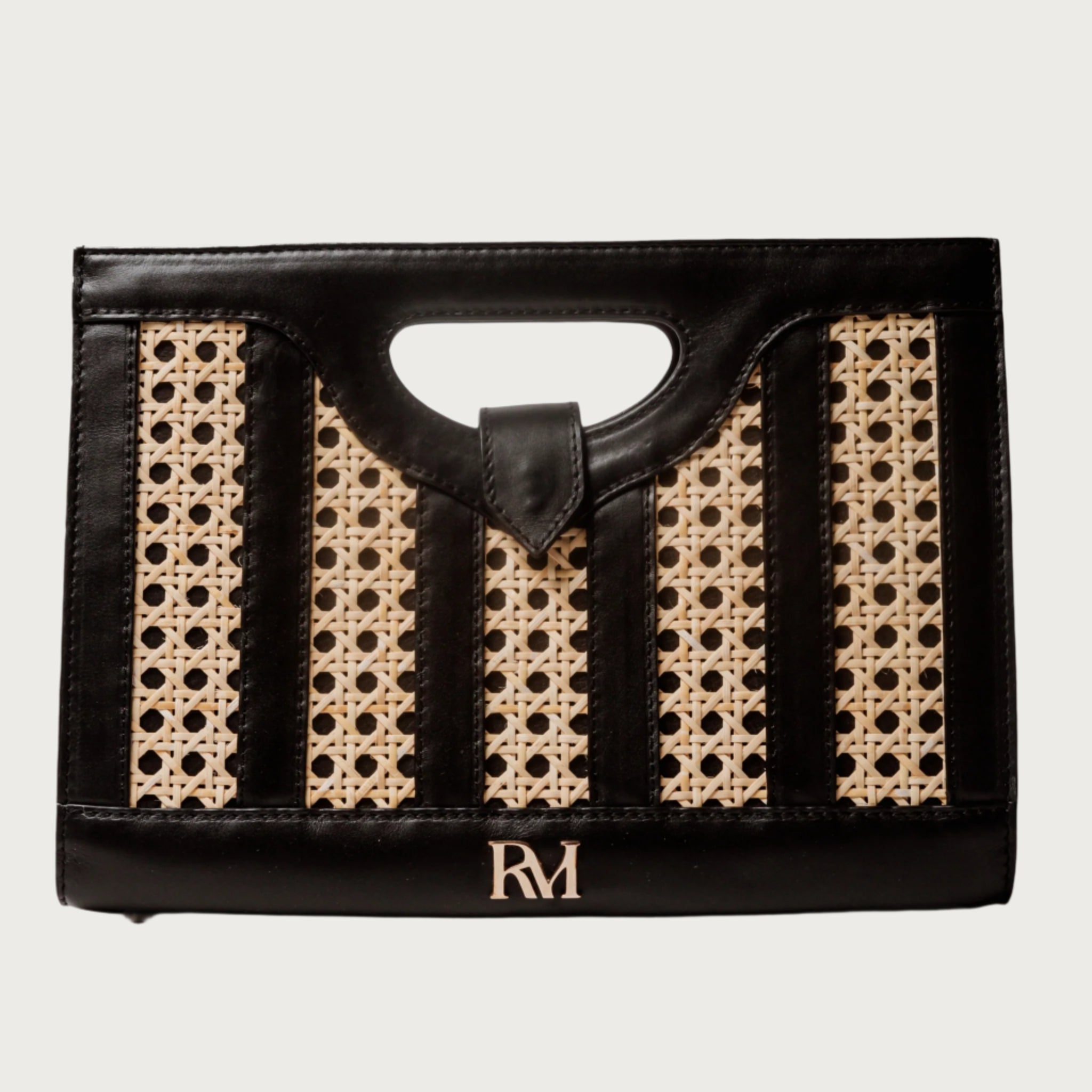 Handwoven wicker and black leather clutch with structured silhouette, cutout handle, and fabric lining bold elegant design