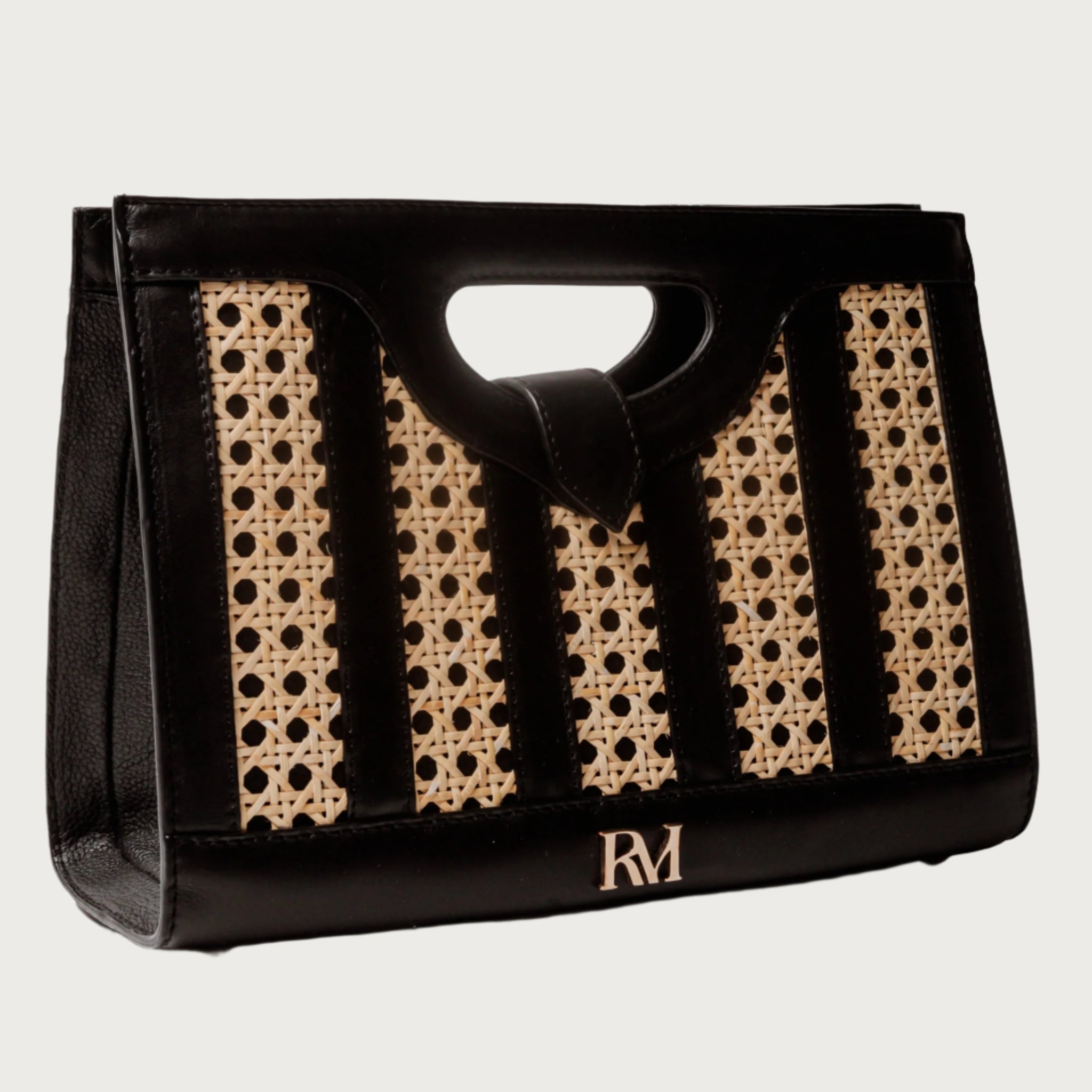 Handwoven wicker and black leather clutch with structured silhouette, cutout handle, and fabric lining bold elegant design