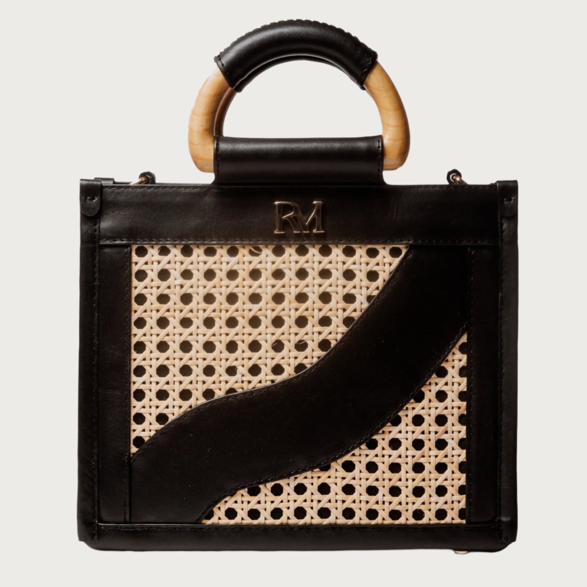 Structured square handbag with handwoven cane body, black leather trim, top handles, and crossbody strap — bold refined look