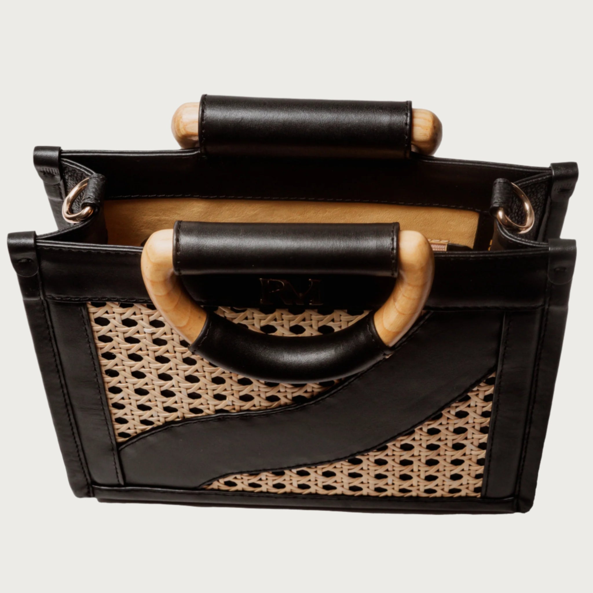 Structured square handbag with handwoven cane body, black leather trim, top handles, and crossbody strap — bold refined look