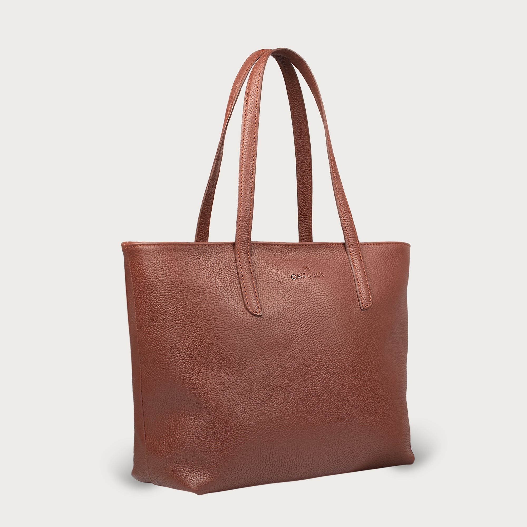 Leather tote made from top-grain leather, featuring smooth golden zipper, inner pouch, and structured design for daily use.
