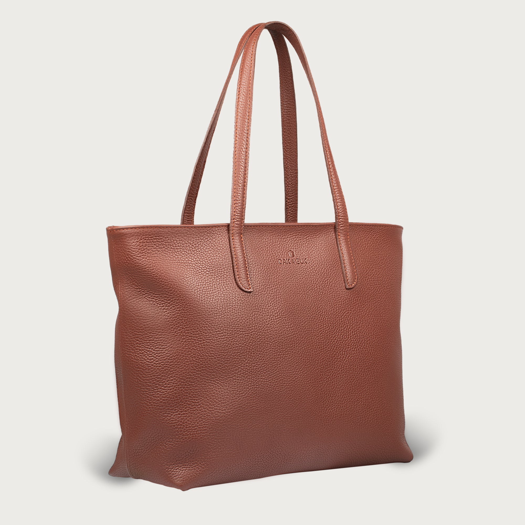 Leather tote made from top-grain leather, featuring smooth golden zipper, inner pouch, and structured design for daily use.