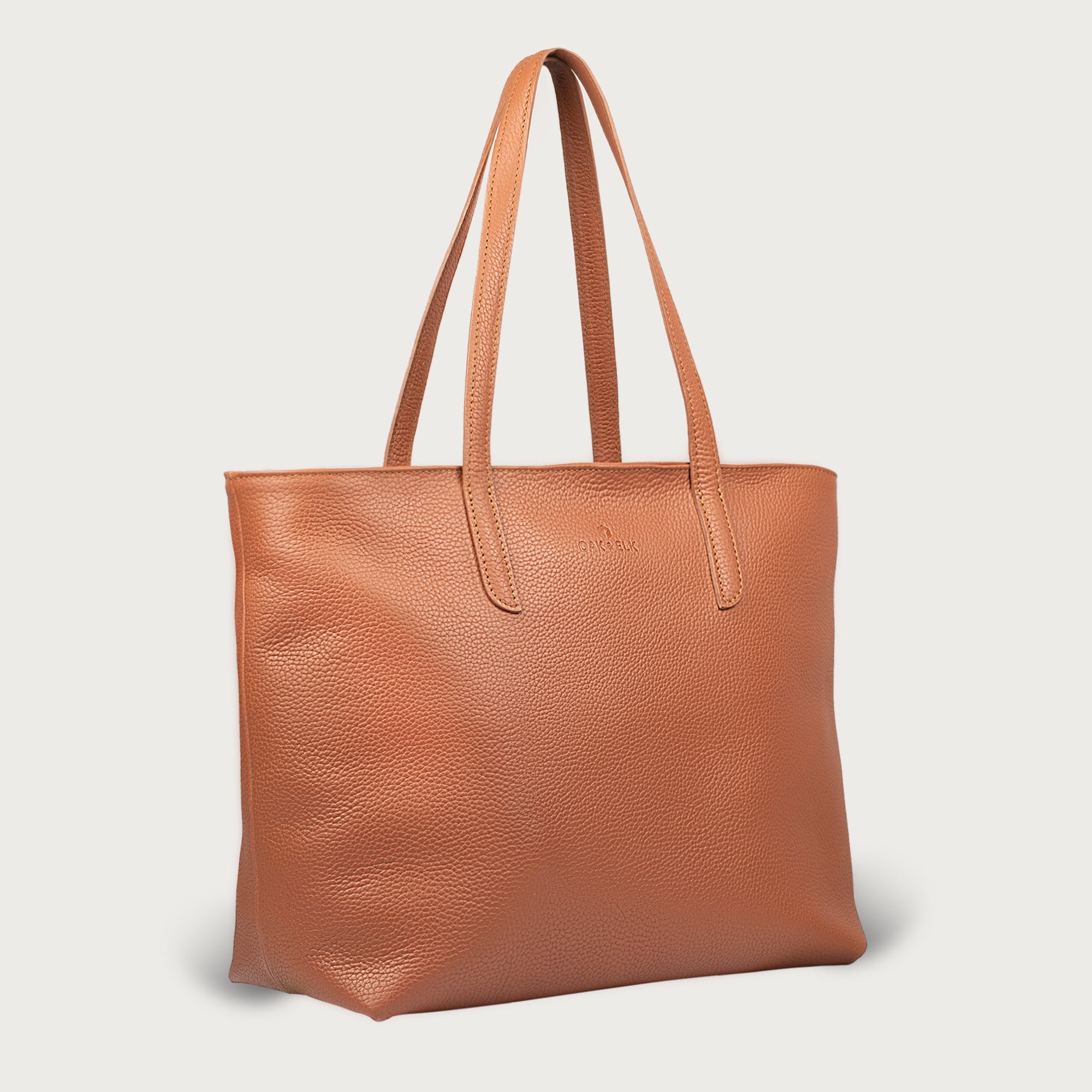 Leather tote made from top-grain leather, featuring smooth golden zipper, inner pouch, and structured design for daily use.