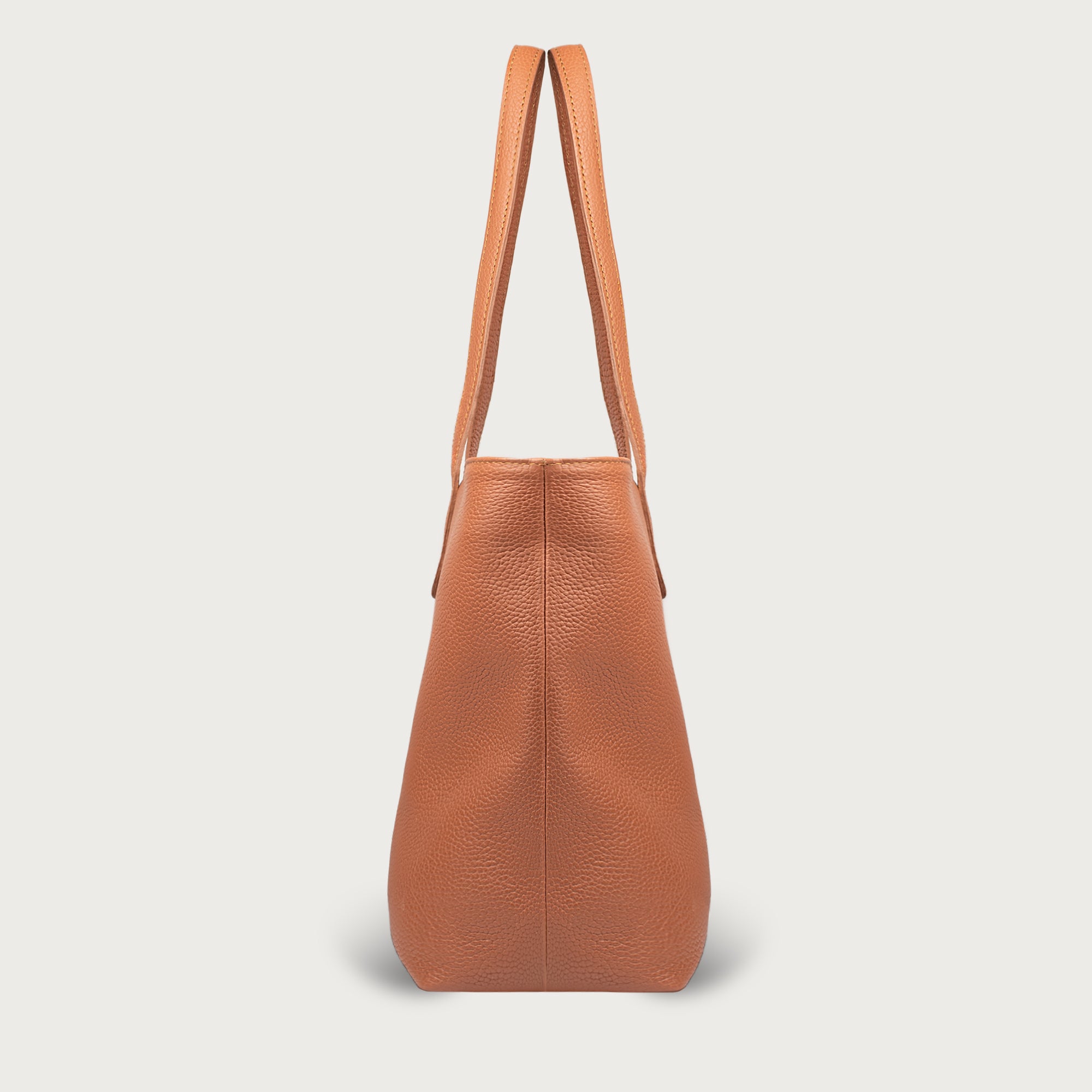 Leather tote made from top-grain leather, featuring smooth golden zipper, inner pouch, and structured design for daily use.