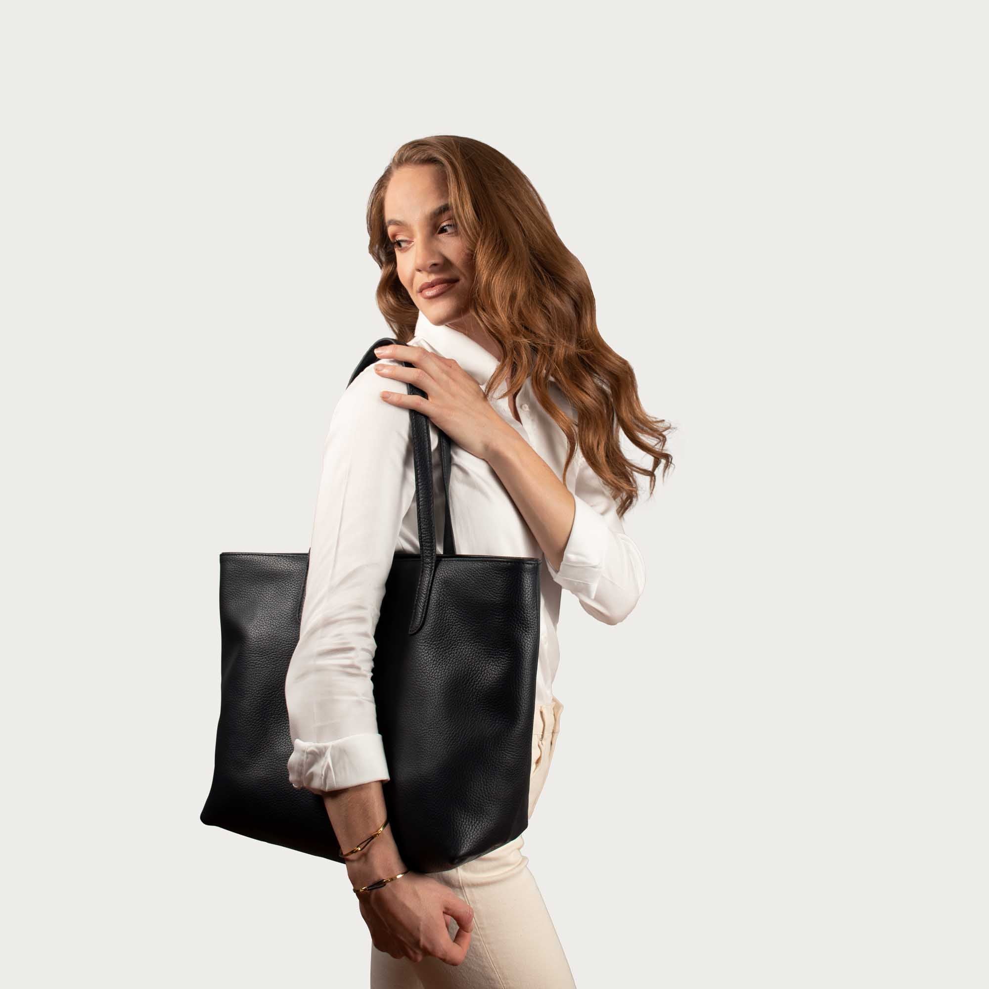 Leather tote made from top-grain leather, featuring smooth golden zipper, inner pouch, and structured design for daily use.