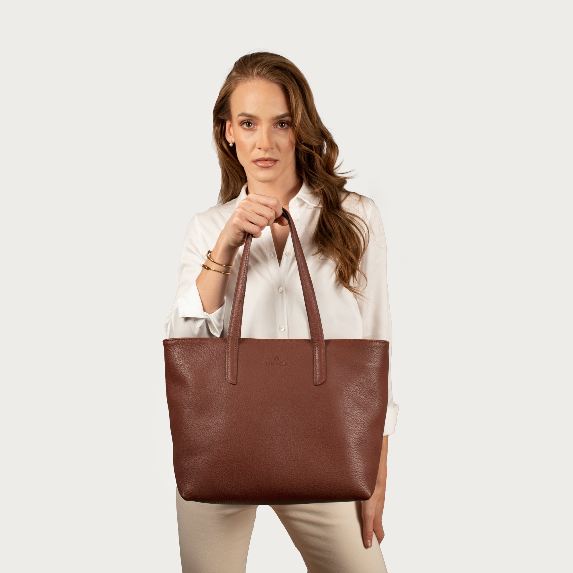 Leather tote made from top-grain leather, featuring smooth golden zipper, inner pouch, and structured design for daily use.