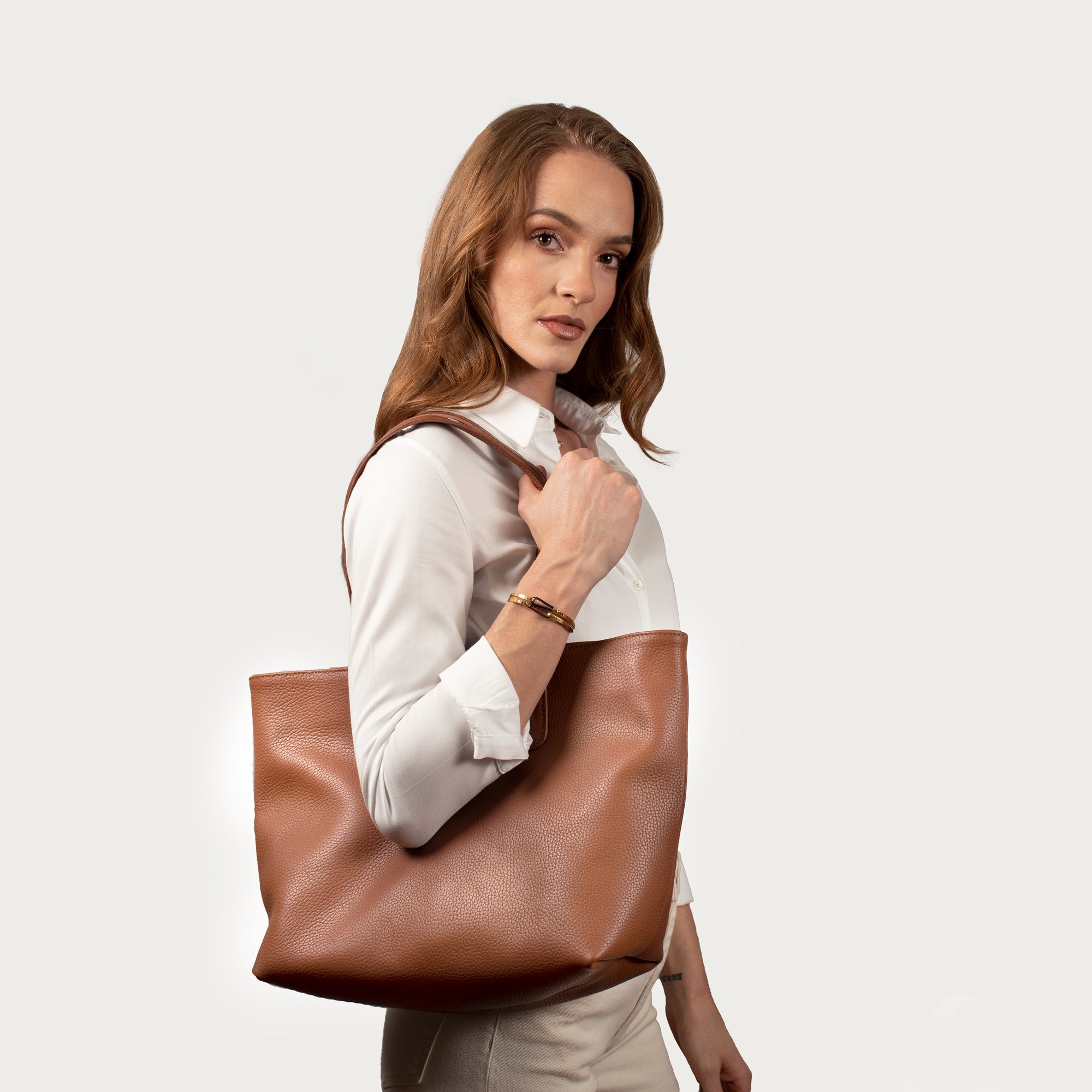 Leather tote made from top-grain leather, featuring smooth golden zipper, inner pouch, and structured design for daily use.