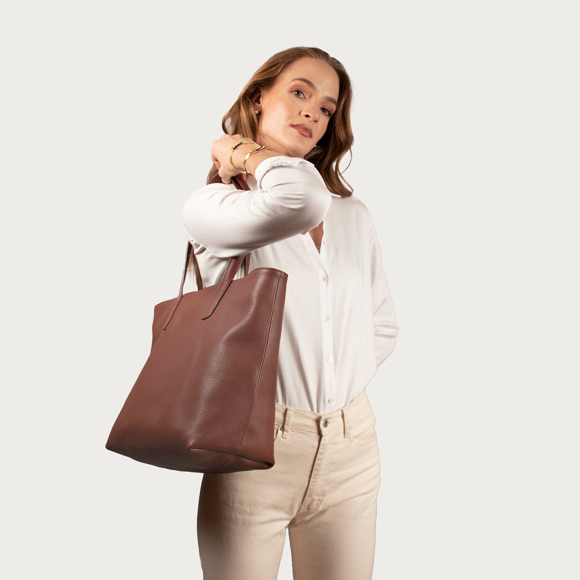 Leather tote made from top-grain leather, featuring smooth golden zipper, inner pouch, and structured design for daily use.