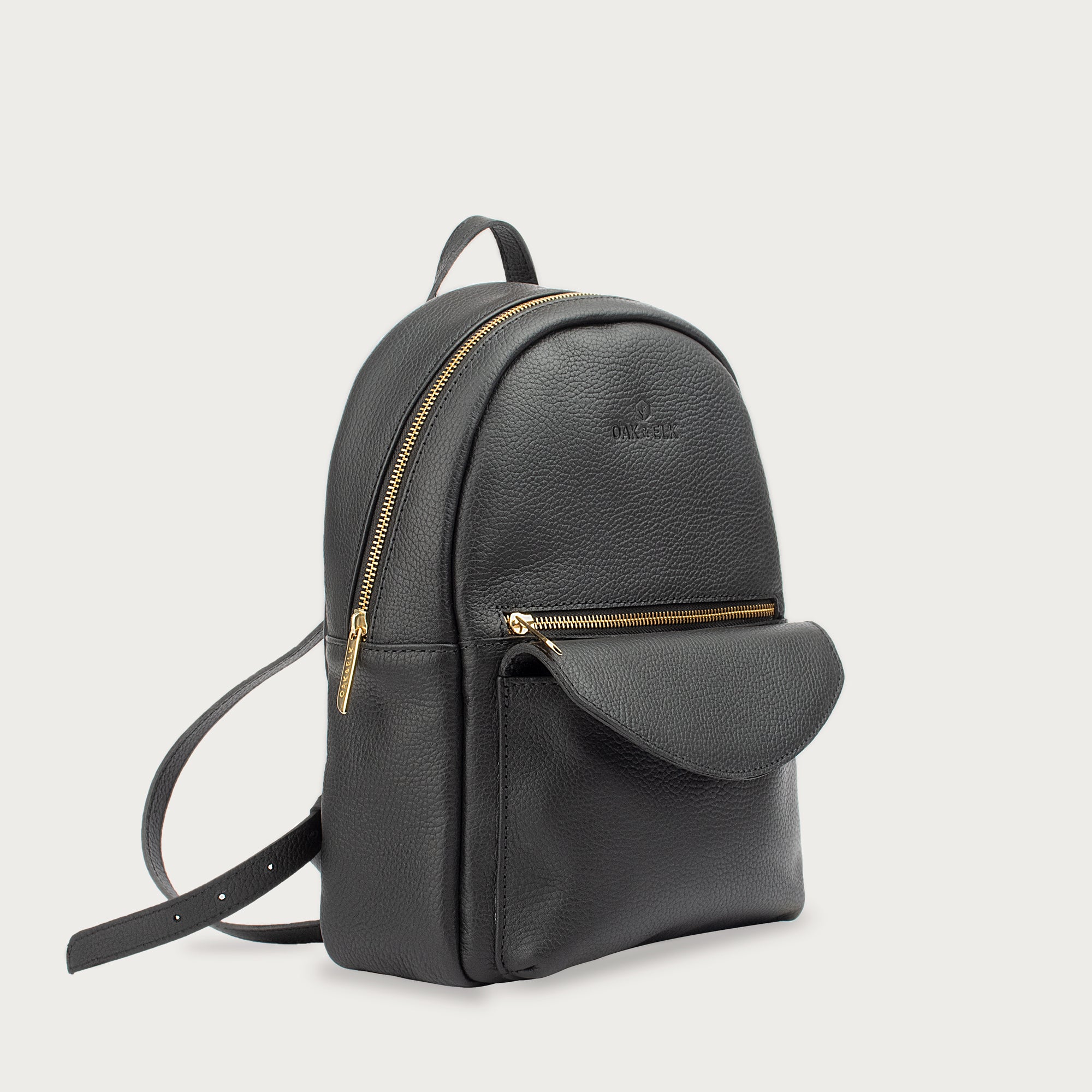 Leather backpack with smooth finish, adjustable straps, front zipper pocket, and gold hardware – Emma by OAK & ELK.
