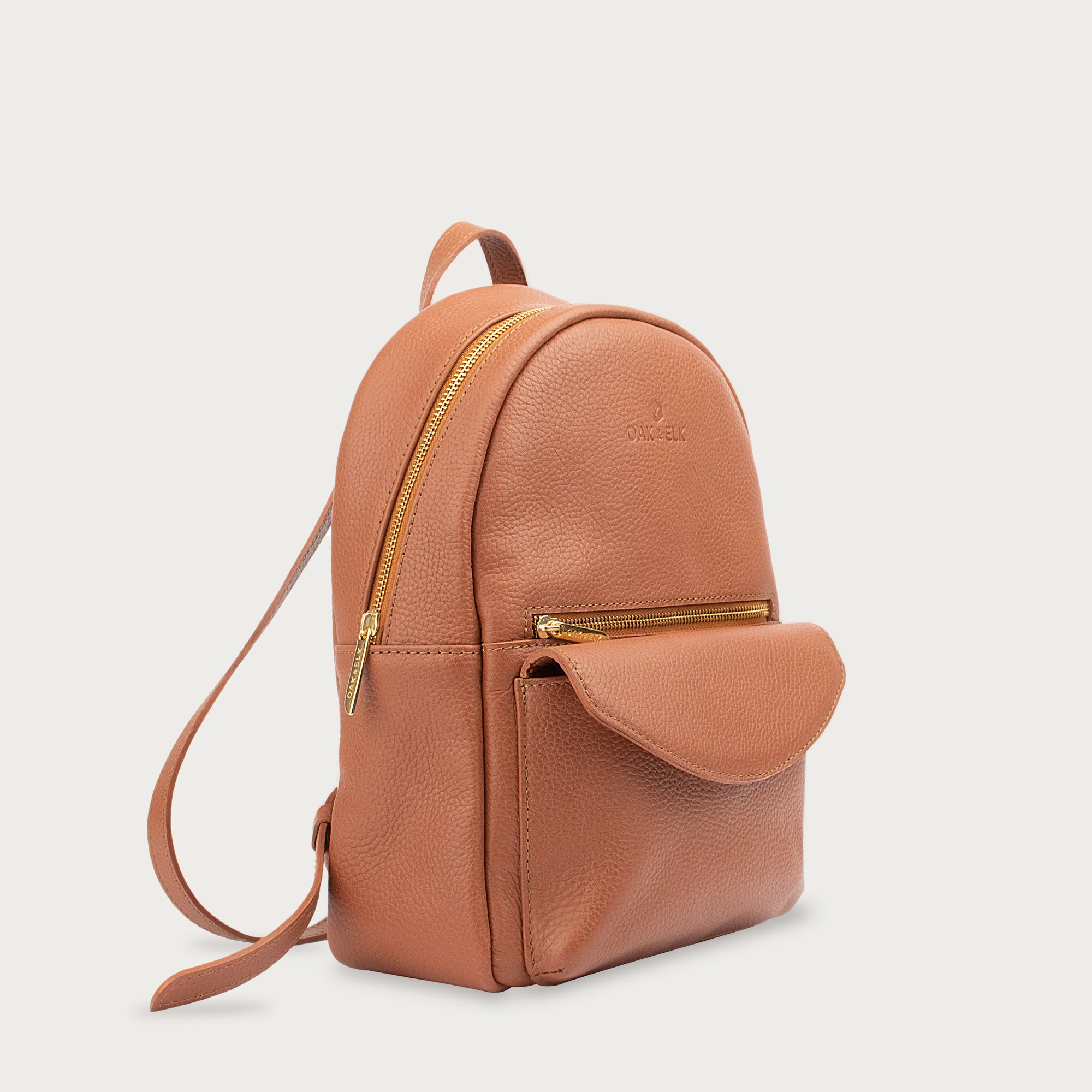 Leather backpack with smooth finish, adjustable straps, front zipper pocket, and gold hardware – Emma by OAK & ELK.