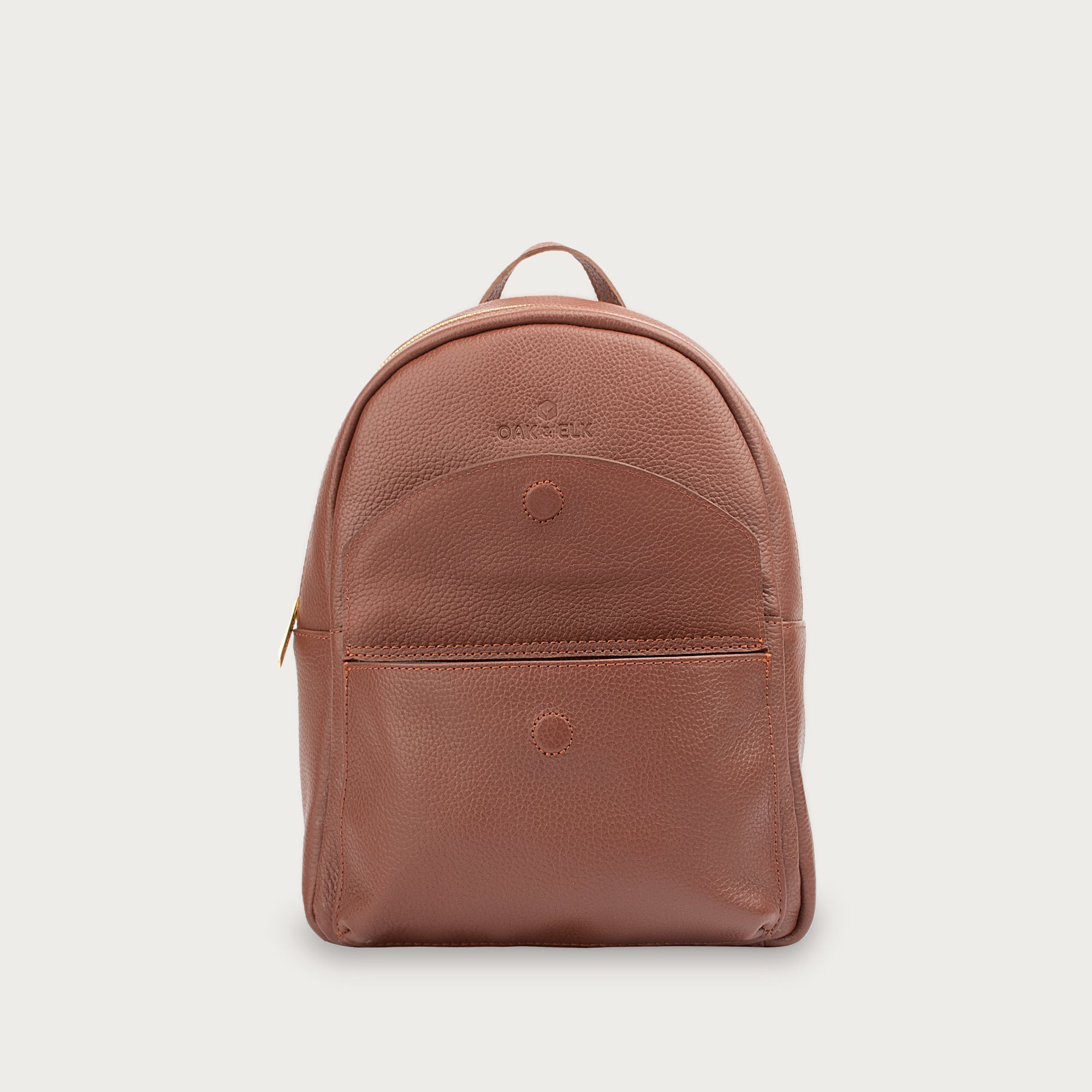 Leather backpack with smooth finish, adjustable straps, front zipper pocket, and gold hardware – Emma by OAK & ELK.