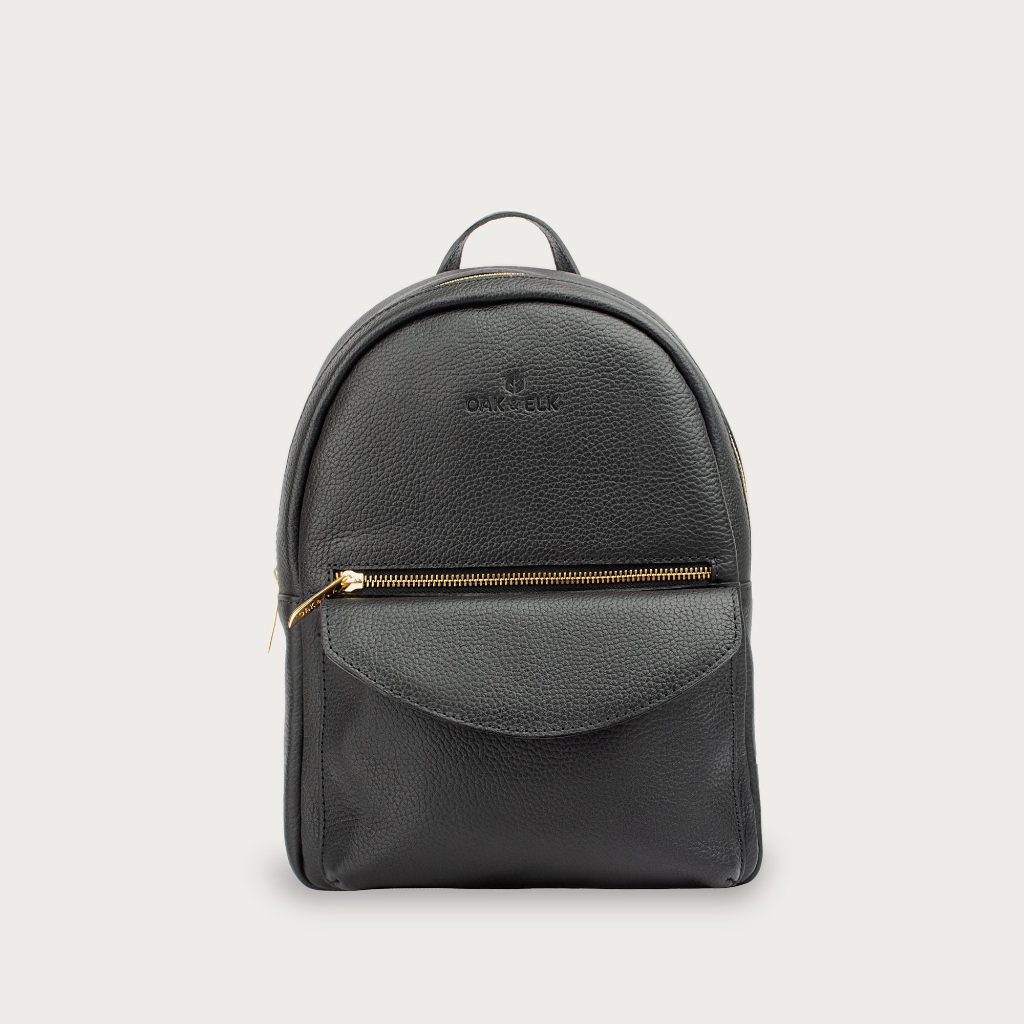 Leather backpack with smooth finish, adjustable straps, front zipper pocket, and gold hardware – Emma by OAK & ELK.