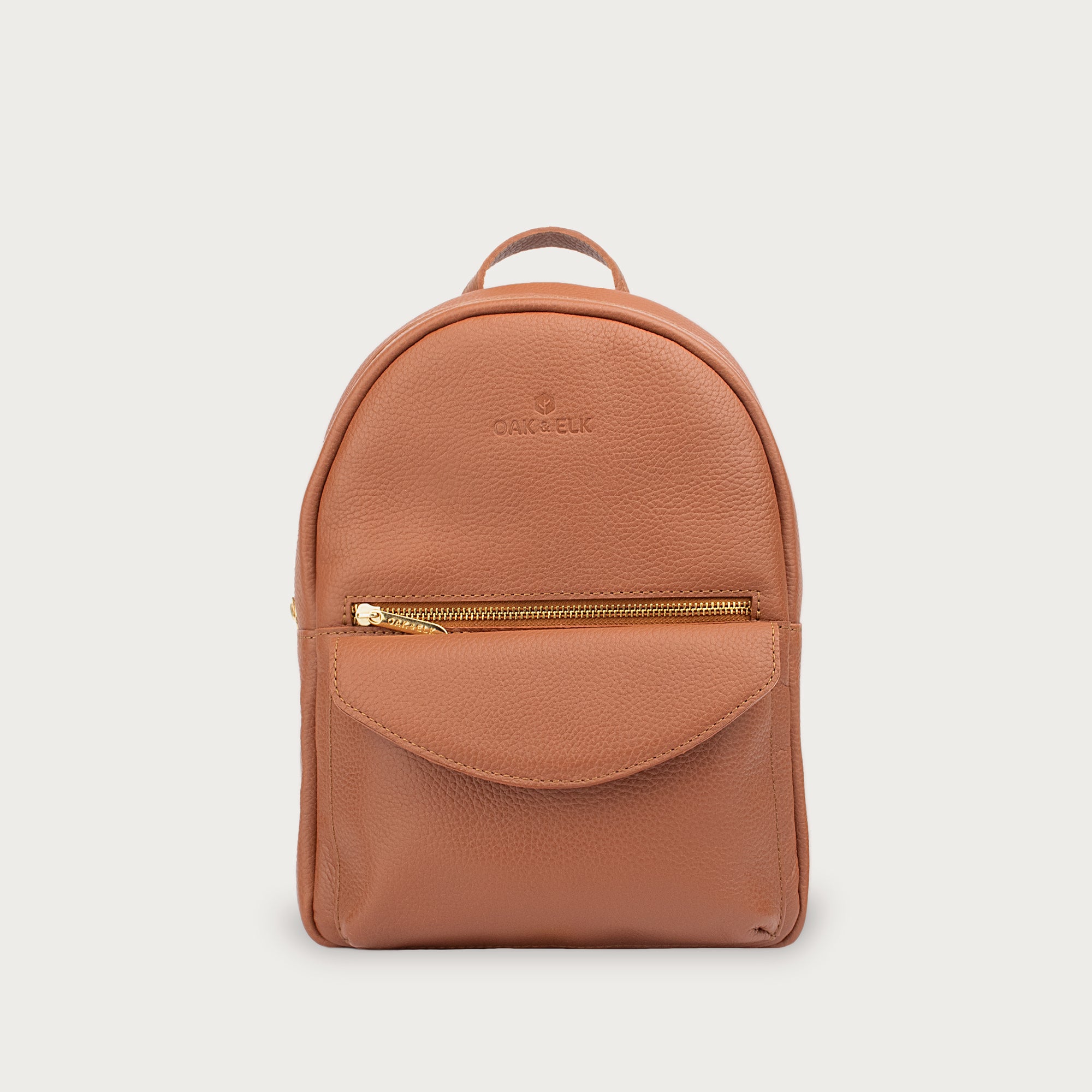 Leather backpack with smooth finish, adjustable straps, front zipper pocket, and gold hardware – Emma by OAK & ELK.