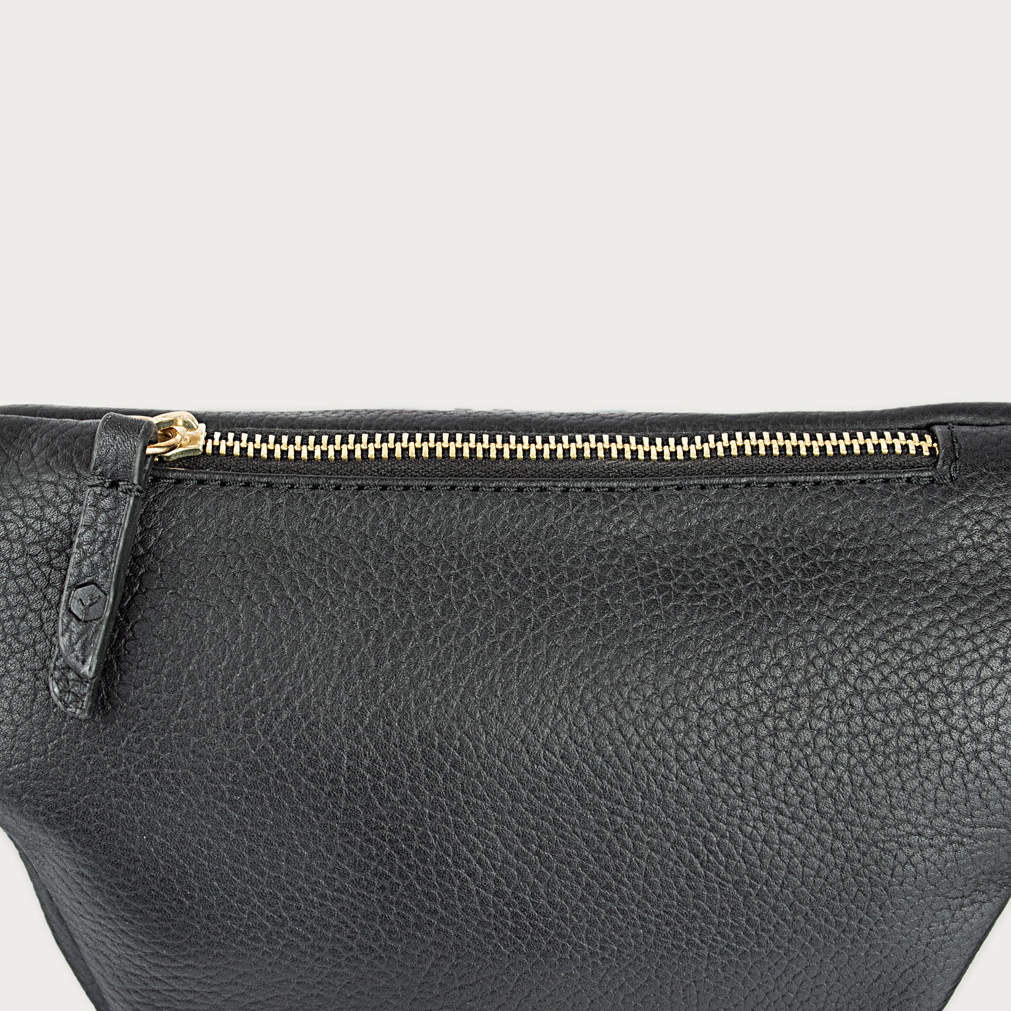 Black leather fanny pack with multiple compartments, zipper pockets, and adjustable strap — sleek and practical for daily use