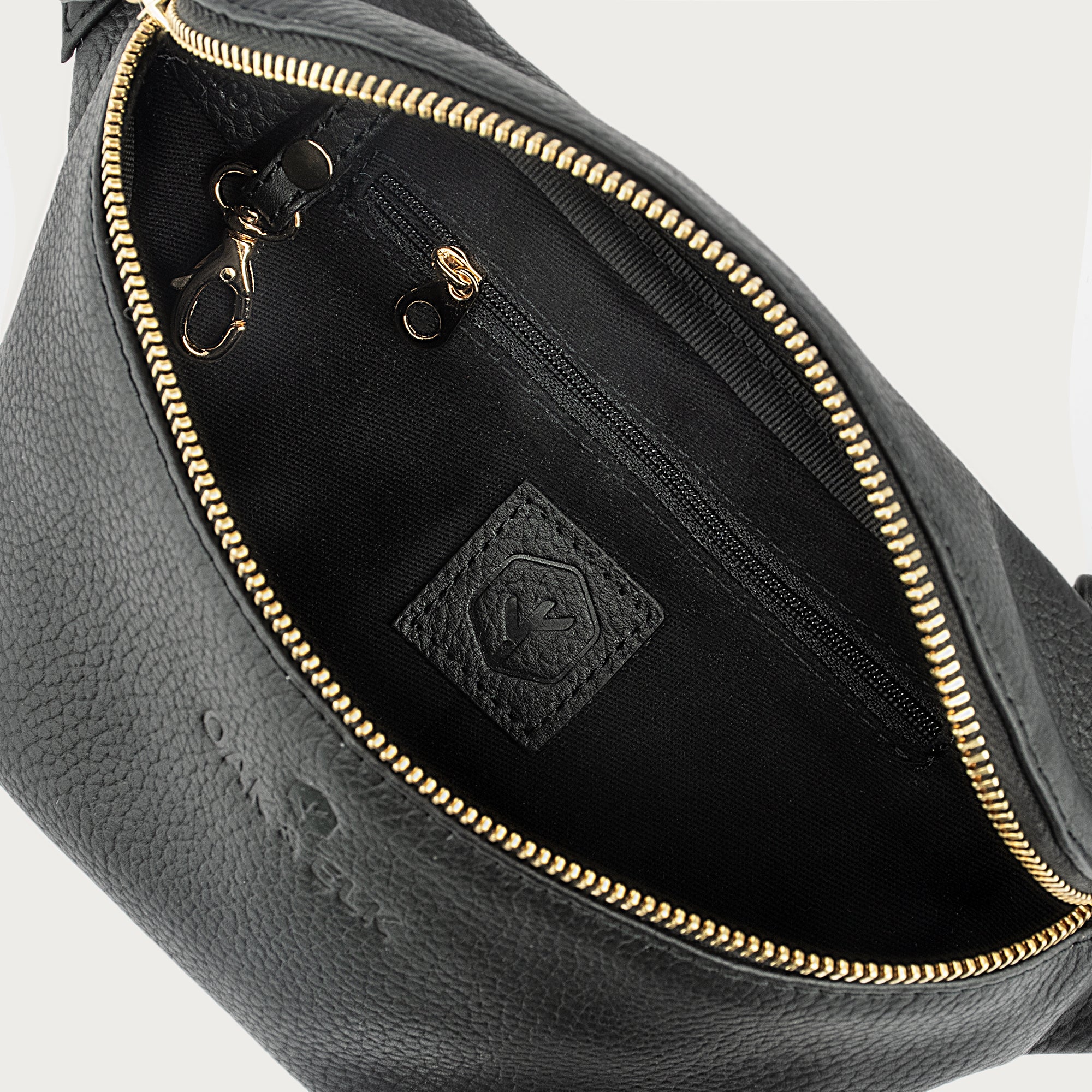 Black leather fanny pack with multiple compartments, zipper pockets, and adjustable strap — sleek and practical for daily use