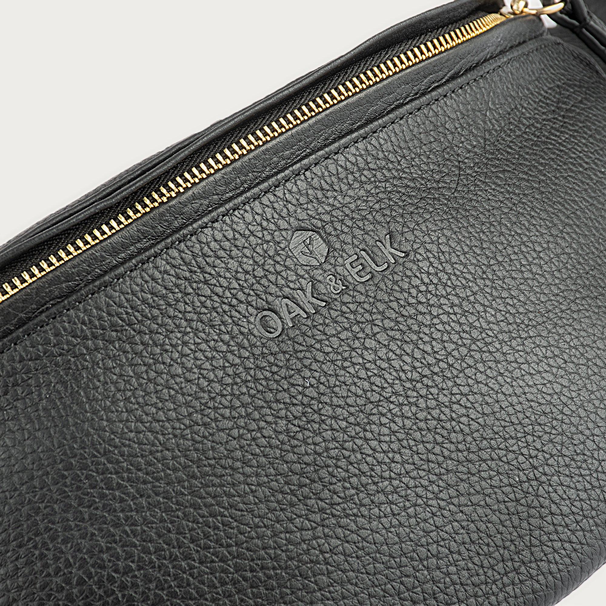 Large black leather fanny pack with multiple compartments, zipper pockets, adjustable strap — sleek practical for daily use