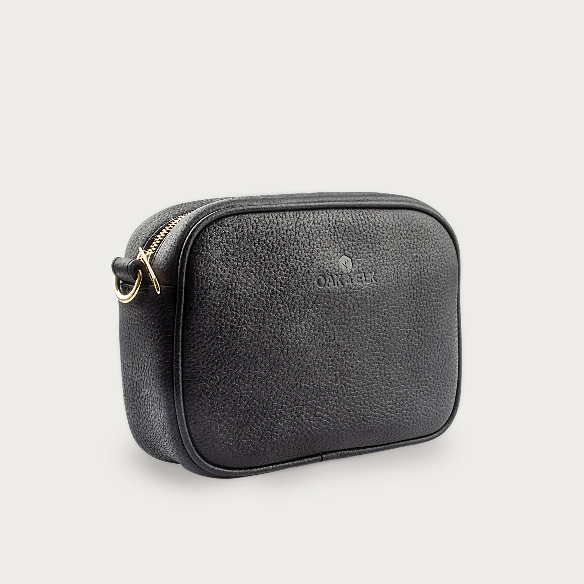 Black leather camera bag with gold zipper, adjustable crossbody strap, and compact design — ideal for essentials on the go.