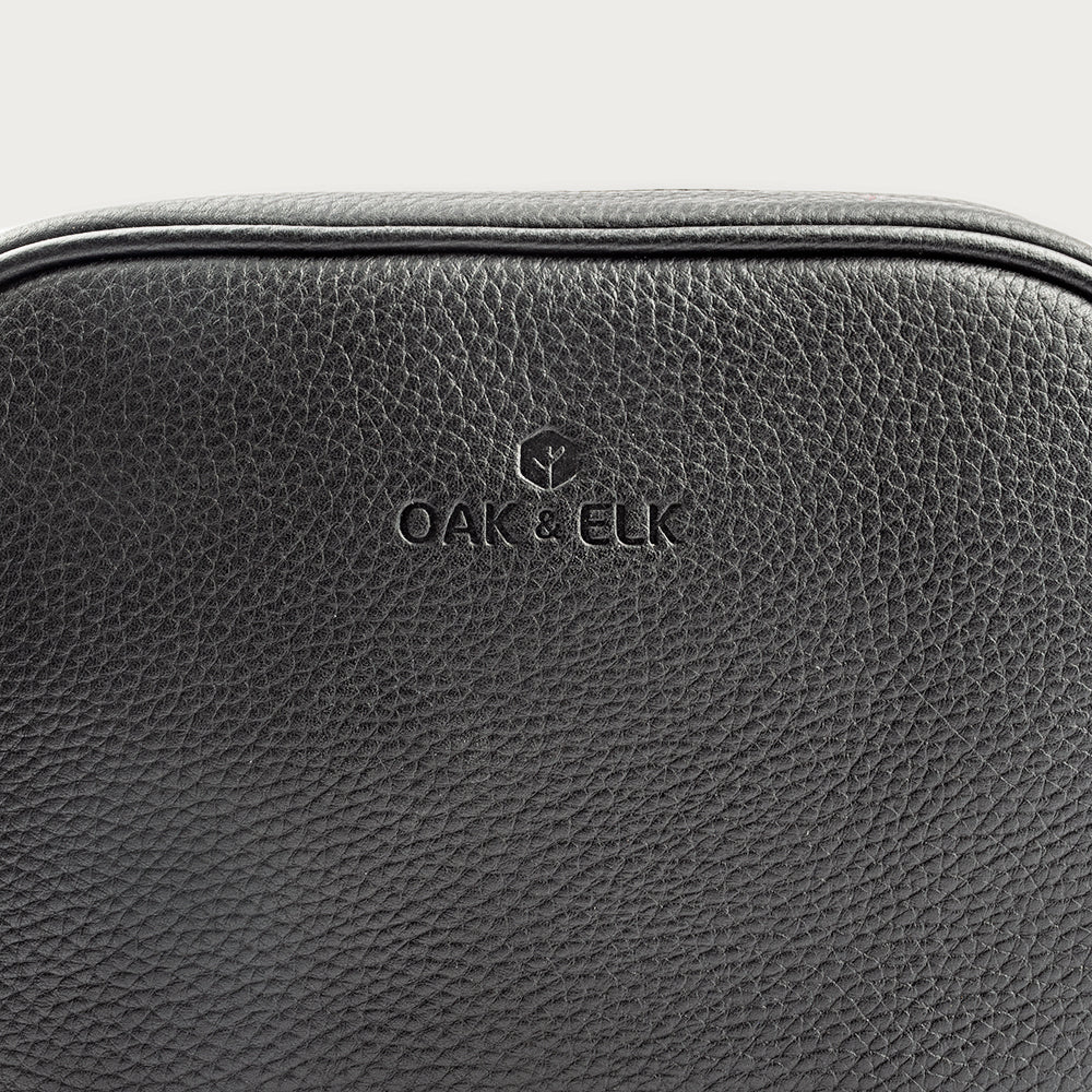 Black leather camera bag with gold zipper, adjustable crossbody strap, and compact design — ideal for essentials on the go.