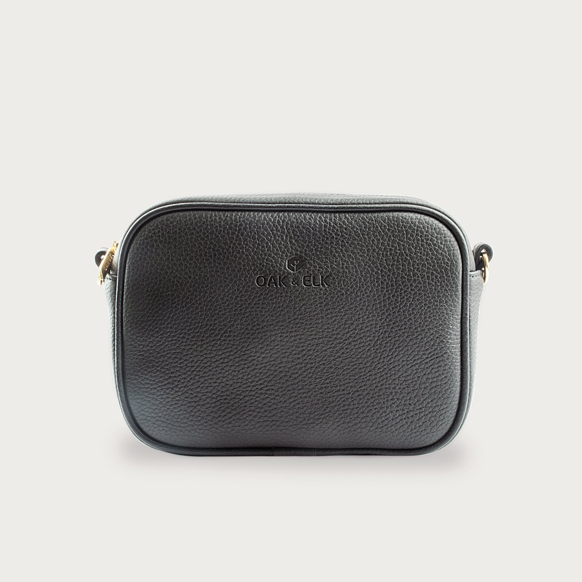 Black leather camera bag with gold zipper, adjustable crossbody strap, and compact design — ideal for essentials on the go.