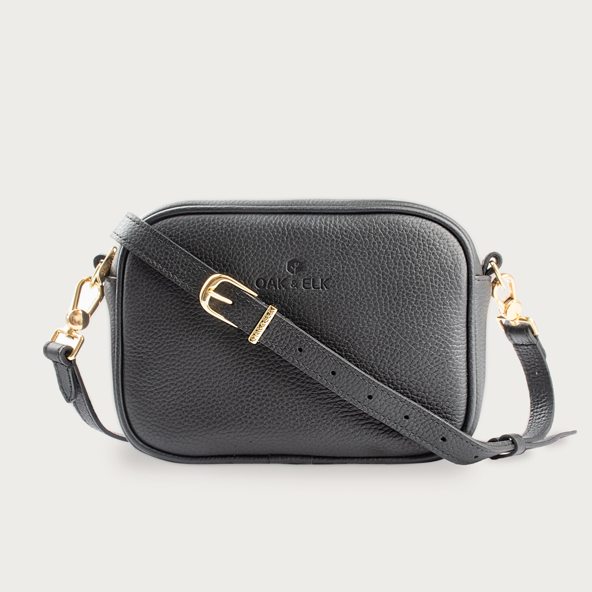 Black leather camera bag with gold zipper, adjustable crossbody strap, and compact design — ideal for essentials on the go.