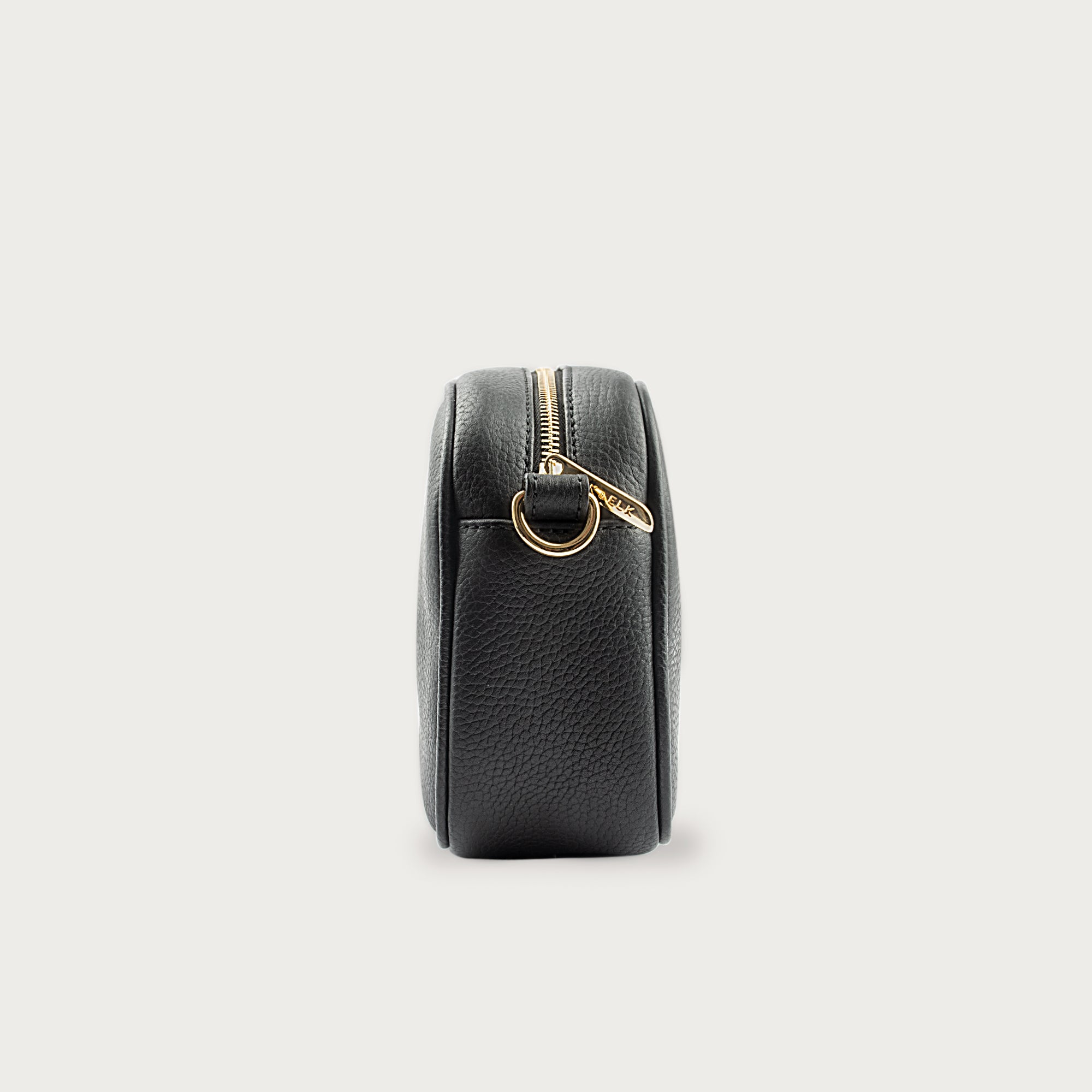 Black leather camera bag with gold zipper, adjustable crossbody strap, and compact design — ideal for essentials on the go.