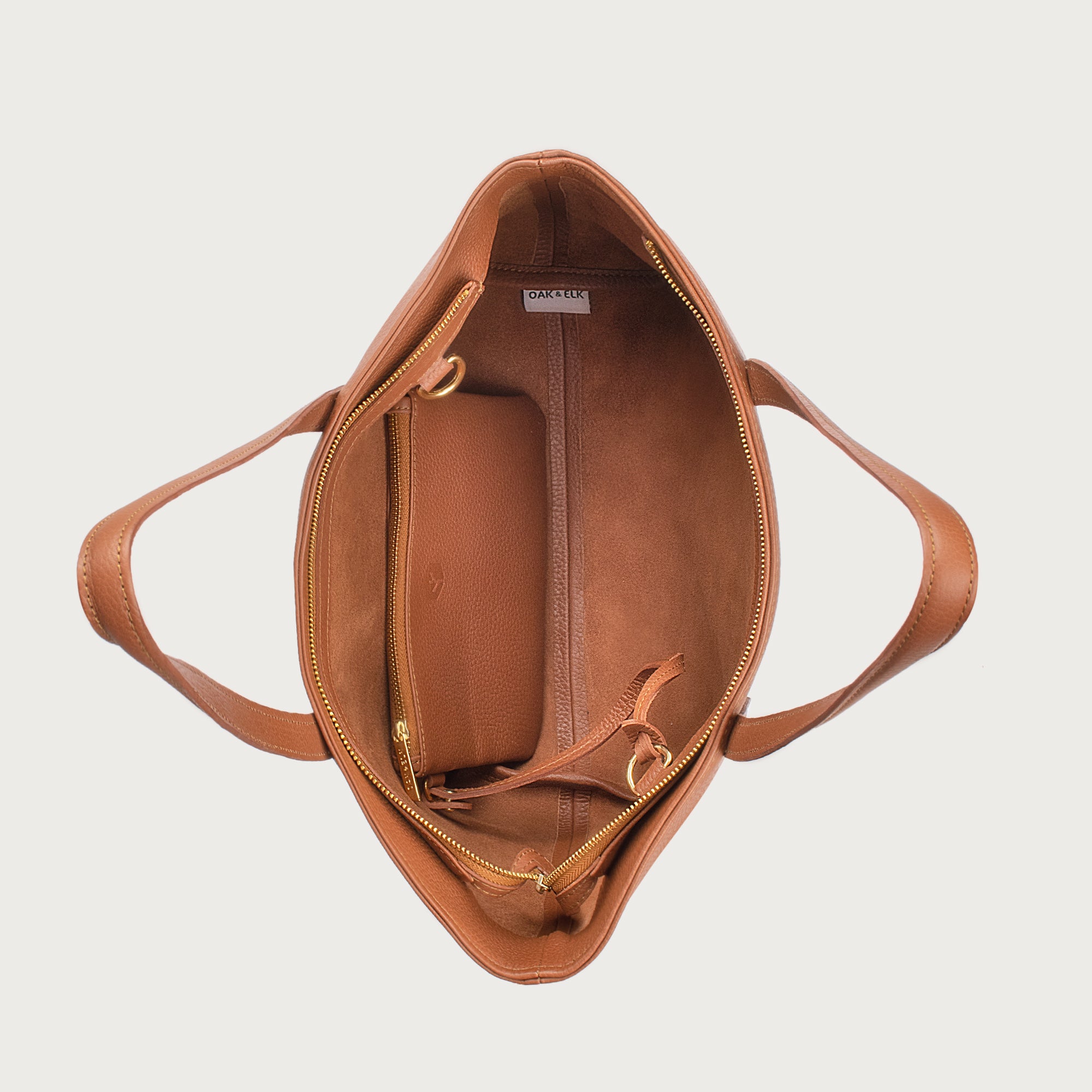 Leather tote made from top-grain leather, featuring smooth golden zipper, inner pouch, and structured design for daily use.